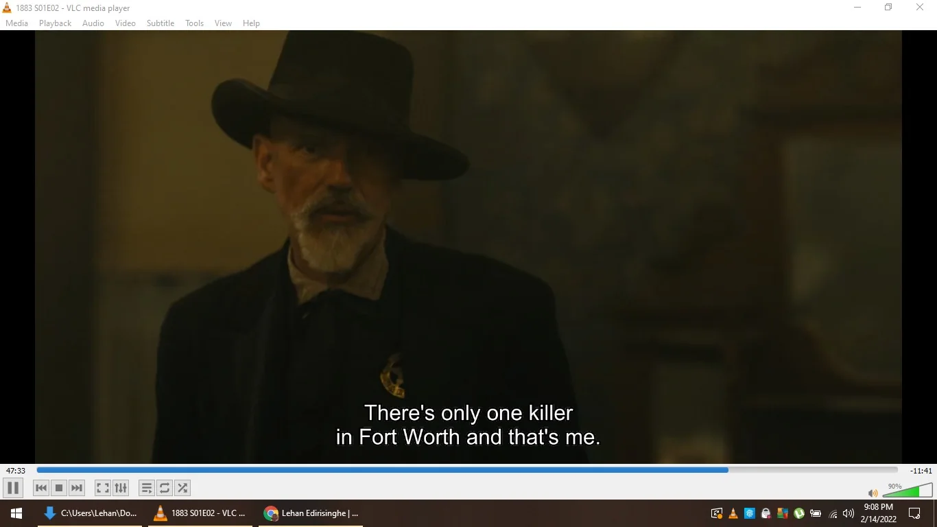 In this image, the scene is from the television series "1883," featuring Sheriff Jim Courtright, played by Billy Bob Thornton. The character is depicted indoors, enveloped in a dramatic and tense atmosphere. He sports a dark hat with a wide brim and a matching suit, projecting an authoritative and rugged demeanor typical of Western dramas. The lighting is dim, highlighting his serious expression as he declares, "There's only one killer in Fort Worth and that's me," underscoring his formidable presence. The video's interface indicates it is being played on VLC media player, with the progress bar and media controls visible at the bottom. This setting and the character's attire contribute to the historical and dramatic tone of the series, immersing the viewer in the gritty world of the American frontier.