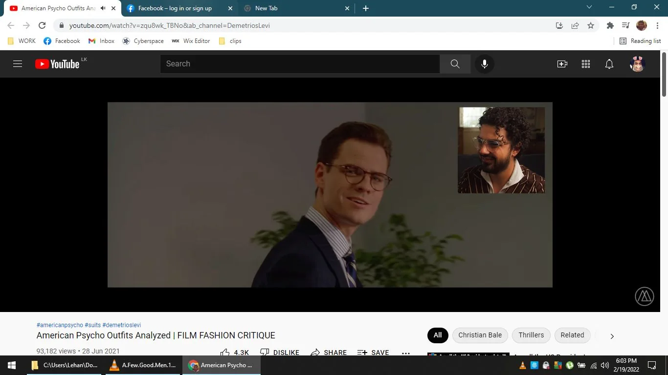 The screenshot is from a YouTube video titled "American Psycho Outfits Analyzed | FILM FASHION CRITIQUE" from the channel Demetrios Levi. The video is a fashion critique analyzing the outfits in the film "American Psycho." On the left side of the screen, a scene from the movie is shown, featuring a character who resembles Patrick Bateman, characterized by a slick hairstyle wearing glasses and a suit, with a confident expression. The background is plain, possibly an office setting, with a small plant visible.
In the upper right corner, there is an inset of a man with curly hair and glasses, likely providing commentary on the attire. He is wearing a brown pinstripe suit with a white shirt, smiling as he engages with the primary video content. The layout indicates a reaction or commentary video format, with the commentary window overlaid on the main film clip.
- Title: "American Psycho Outfits Analyzed | FILM FASHION CRITIQUE"
- Channel / profile: "Demetrios Levi"
- Site / app: "YouTube"