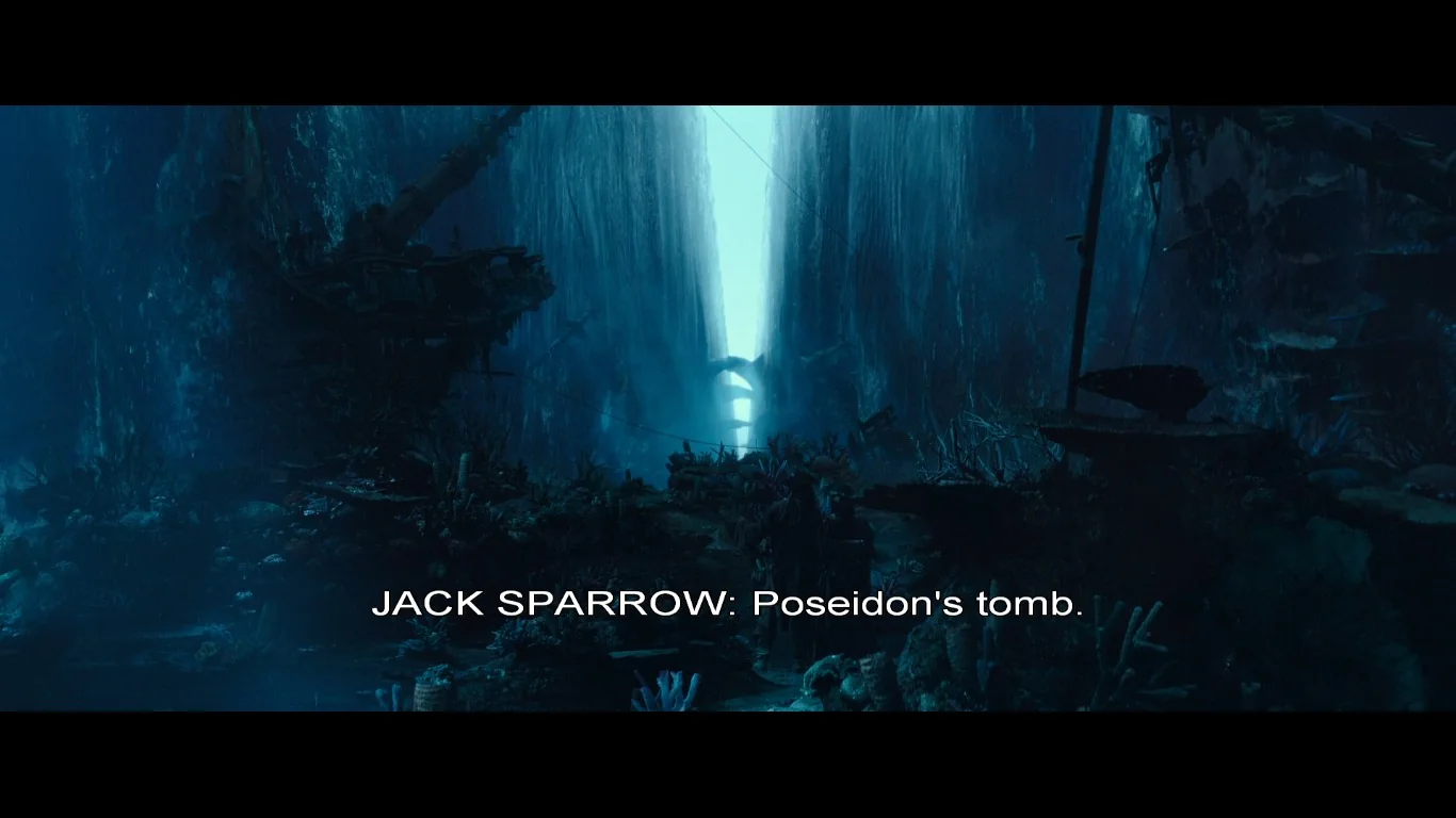 The image is a dramatic underwater scene from the movie "Pirates of the Caribbean." The setting is dark and mystical, with a narrow canyon-like structure, giving the impression of a submerged tomb. The lighting is dim, with a blue-green hue permeating the scene, enhancing the mysterious and eerie atmosphere. The water is clear enough to see various shipwrecks and marine debris scattered around, adding to the ancient and forgotten feel of the place. In the background, a faint light source creates a focal point, drawing attention down the watery corridor.
The subtitle reads "JACK SPARROW: Poseidon's tomb," indicating the presence of the character Jack Sparrow, known for his adventurous and cunning nature. This suggests a significant moment in the film involving a mythical location. The overall composition reflects a blend of adventure and fantasy typical of the "Pirates of the Caribbean" series, with an emphasis on exploration and the supernatural.