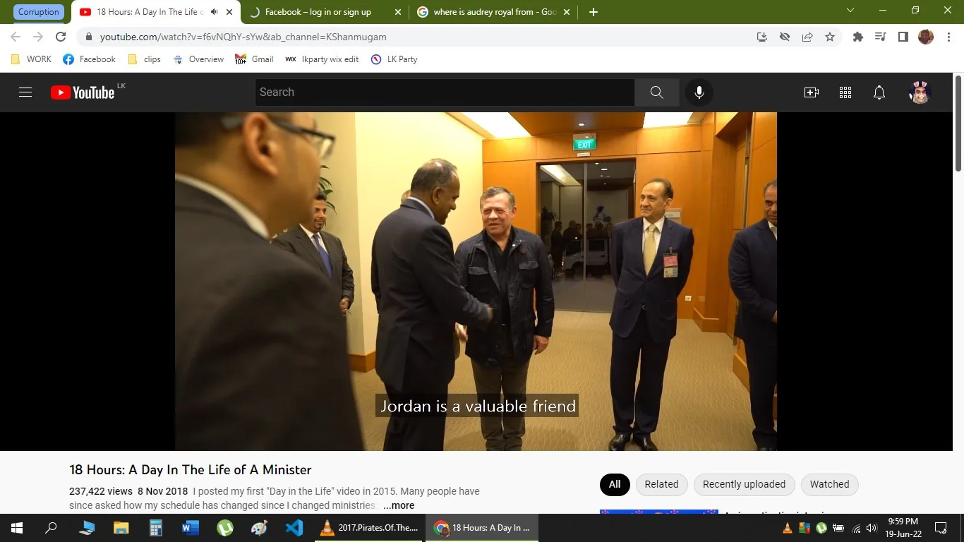 The image is a video frame from a YouTube video titled "18 Hours: A Day In The Life of A Minister" on the channel KShanmugam. The scene takes place indoors in a formal setting, possibly an office or conference room. The lighting is bright, and the walls are a warm, light brown color, giving a professional and welcoming atmosphere.
In the foreground, two men are engaged in a handshake, indicating a gesture of diplomacy and friendship. One of the men, based on the user hint, is K Shanmugam. They are both dressed in formal attire; K Shanmugam is likely in a suit, reflecting the formality of the occasion. There are other individuals in the background, all dressed in suits, suggesting a meeting or diplomatic event.
The subtitle "Jordan is a valuable friend" is visible, implying a discussion related to international relations. The mood appears cordial and respectful, with the participants' expressions focused and engaged. This visual captures a moment of diplomatic interaction, emphasizing the themes of friendship and collaboration between nations.