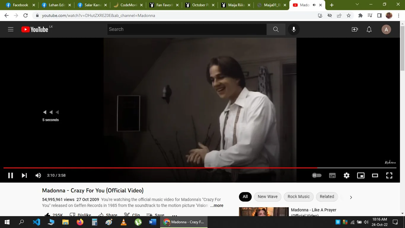 The image is a screenshot from YouTube featuring the music video for "Crazy For You" by Madonna. The scene shows a person indoors, wearing a white shirt with suspenders, smiling warmly. The background is subtle, with dim lighting typical of 1980s music videos, contributing to a nostalgic atmosphere. The room appears to be sparsely decorated, with a wall sconce and a partially visible doorway. The video player interface is visible, showing a pause button and a progress bar indicating the video is near its end. Below, the video description provides details like the view count and upload date, emphasizing its status as the official music video. The video is associated with the soundtracks of the motion picture "Vision Quest." The channel name "Madonna" is displayed prominently, and a few interactive elements like the like and dislike buttons are visible. Overall, the scene captures a moment from a classic music video, evoking a sense of nostalgia.
- Title: "Madonna - Crazy For You (Official Video)"
- Channel / profile: "Madonna"
- Site / app: "YouTube"
