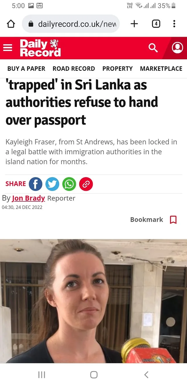 Kayleigh Fraser is depicted in this news article screenshot from the Daily Record website. The headline states that she is "trapped" in Sri Lanka due to the authorities' refusal to return her passport. This image likely shows a moment captured during an interview or news report. The setting appears to be indoors, possibly in a public or official building, as indicated by the tiled walls and ceiling. Kayleigh Fraser is in the foreground, facing the camera, with a serious expression, suggesting the gravity of the situation she is experiencing.
She is holding a microphone from a news outlet, which has a red cover with yellow text, indicating a media interview. The lighting is neutral, typical of indoor environments, and her attire is casual, suitable for an informal yet serious setting. The background shows office-like features, adding to the context of an interview or press statement. The text accompanying the image provides details about her legal struggle with immigration authorities in Sri Lanka, highlighting the personal and emotional challenges she faces. The article was written by Jon Brady and published on December 24, 2022.