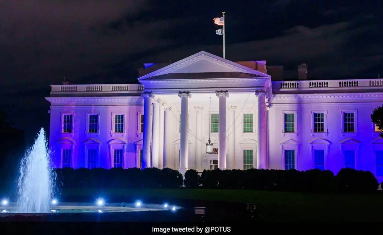The image shows the White House, an iconic landmark in Washington, D.C., illuminated at night with vibrant shades of purple and blue lighting. The building's classical architecture is prominently displayed, featuring its famous columns and symmetrical windows. In the foreground, a fountain is visible, adding a dynamic element to the scene with its water spray highlighted by spotlights. The sky above is dark, contrasting with the bright colors projected onto the building's facade. The American flag is flying atop the White House, adding a patriotic element to the scene. The overall atmosphere is majestic and ceremonial, likely marking a special occasion or event. The illumination of the White House in such colors often signifies awareness or celebration of a significant cause or event. The image was shared on Twitter by the account @POTUS, suggesting official communication from the President of the United States.
- Title: "Image tweeted by @POTUS"
- Channel / profile: "@POTUS"
- Site / app: "Twitter"