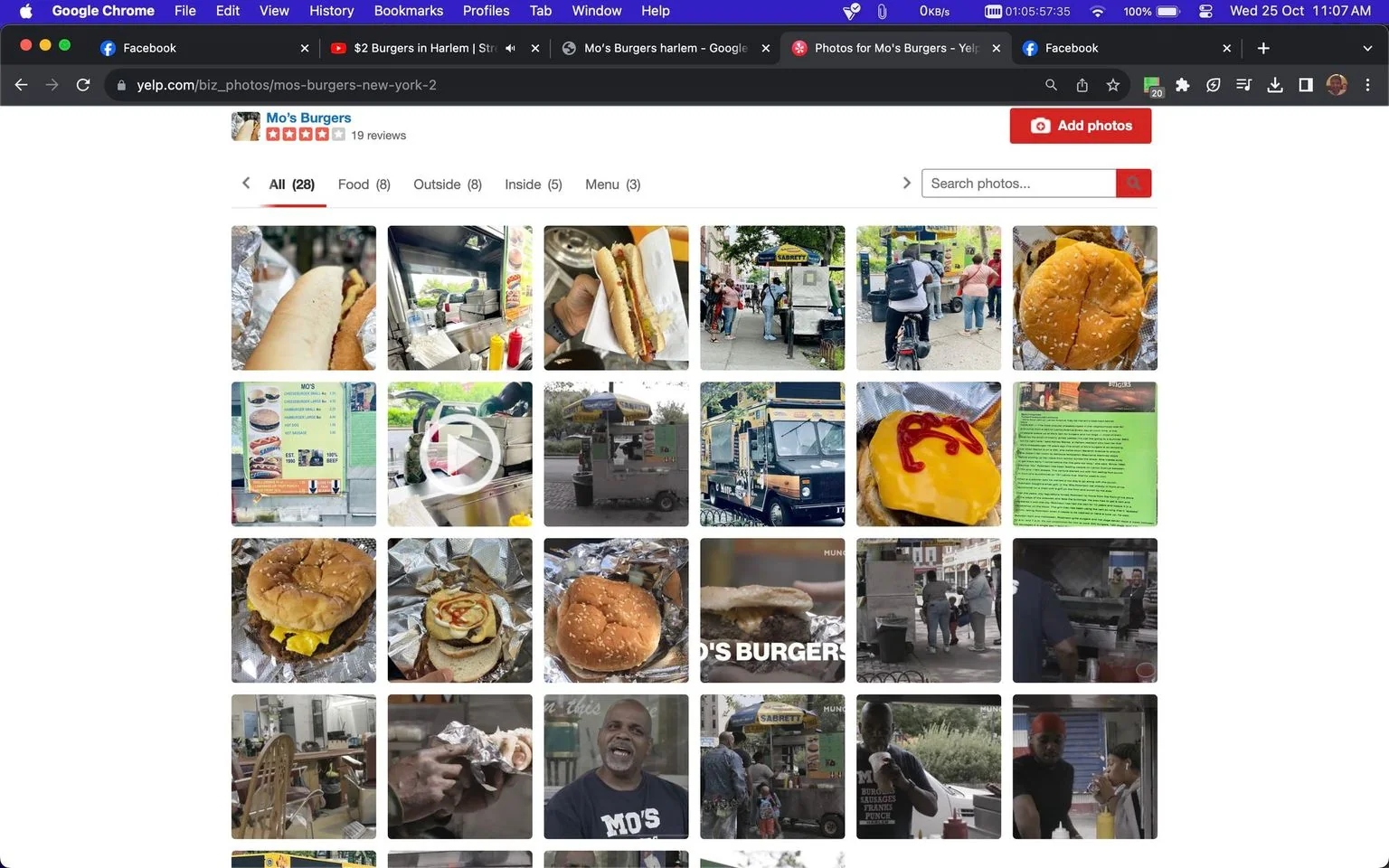 The image is a screenshot of a Yelp page showcasing photos for "Mo's Burgers." The page displays a grid of 28 images, primarily featuring food items such as burgers and hot dogs, along with street vendor scenes. In the center of the top row, there's a close-up of a hot dog in a bun with condiments. Various images show the vendor setup, including a food truck labeled "Mo's Burgers" and a menu board listing available items. People are visible interacting at the food stand and enjoying their meals, conveying a bustling urban atmosphere. The color scheme is vibrant, with the colorful food and bright signage standing out against the street background. The top of the page shows "Mo's Burgers" with 19 reviews, indicating customer feedback. The setting appears to be a lively street scene, suggesting the business's casual and accessible nature.