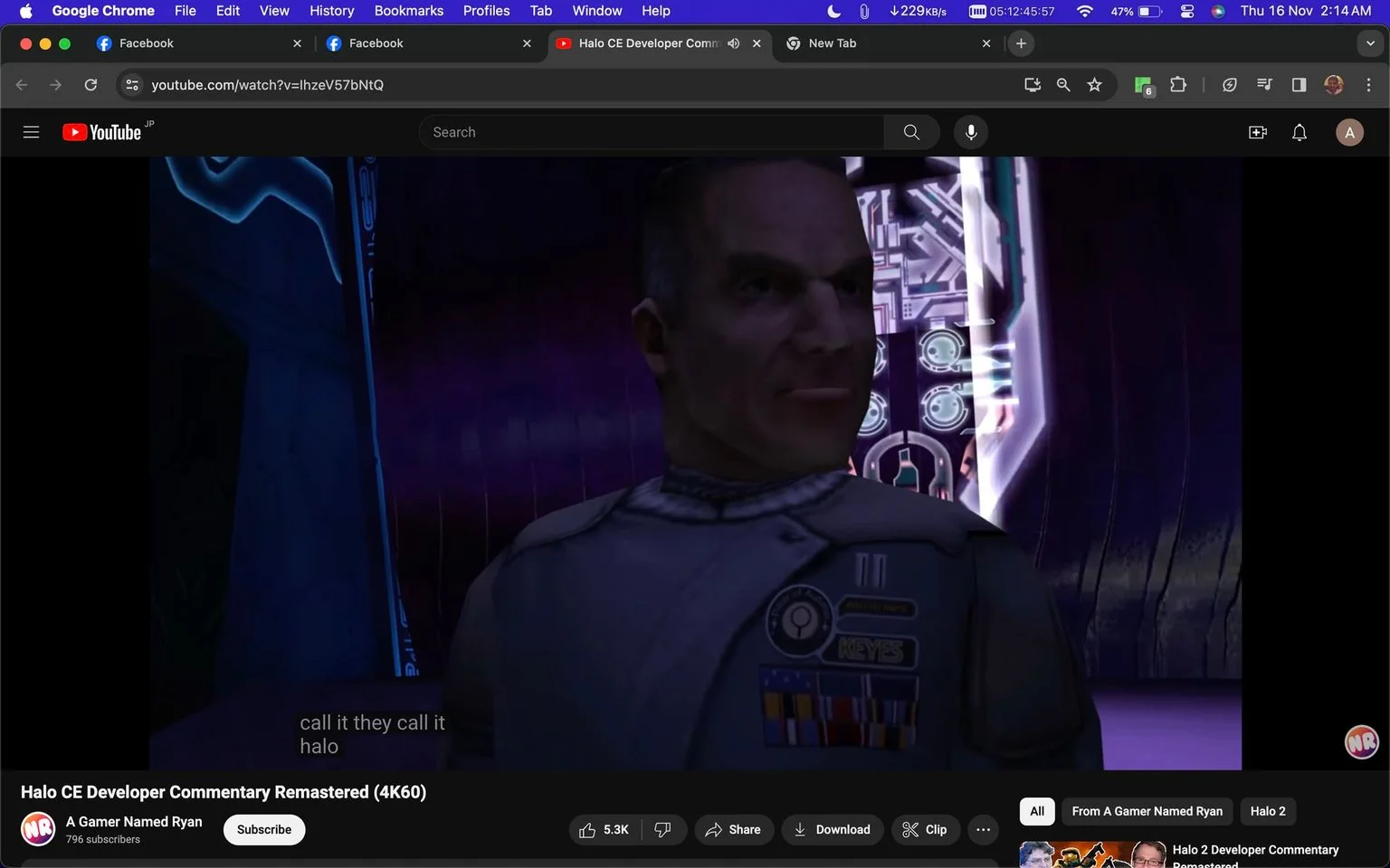 The image is a screenshot from a YouTube video titled "Halo CE Developer Commentary Remastered (4K60)" on the channel "A Gamer Named Ryan." The scene features a character from the game "Halo," standing in a futuristic setting. The character wears a military-style uniform adorned with a badge labeled "KEYES" and several colorful ribbons, indicating a rank or achievements. The background is a sci-fi environment with glowing panels and screens, contributing to the high-tech atmosphere typical of the Halo series. The lighting is dim, with purple and blue hues dominating the scene, casting a dramatic tone. The video is likely a commentary or discussion on the development of "Halo: Combat Evolved," offering insights into its creation and impact. Subtitles at the bottom read, "call it they call it halo," possibly referencing the game's titular feature.