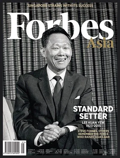 The image is a magazine cover from Forbes Asia, featuring a black and white portrait of Lee Kuan Yew. He is seated, wearing a suit and tie, exuding a dignified and confident demeanor. His expression is a mix of seriousness and warmth, suggesting a moment of reflection or contentment. The background is simple, keeping the focus on Lee Kuan Yew himself. The text on the cover highlights him as a "Standard Setter," noting the years of his life, 1923-2015, indicating a tribute to his legacy. The headline at the top reads, "SINGAPORE STRAINS WITH ITS SUCCESS," suggesting an exploration of Singapore's growth and challenges. Additional text mentions Steve Forbes and others remembering Lee Kuan Yew's impact on Asia. The overall composition and presentation underscore the significance of Lee Kuan Yew's contributions and leadership in shaping Singapore's success.
- Title: "Standard Setter"
- Site / app: "Forbes"