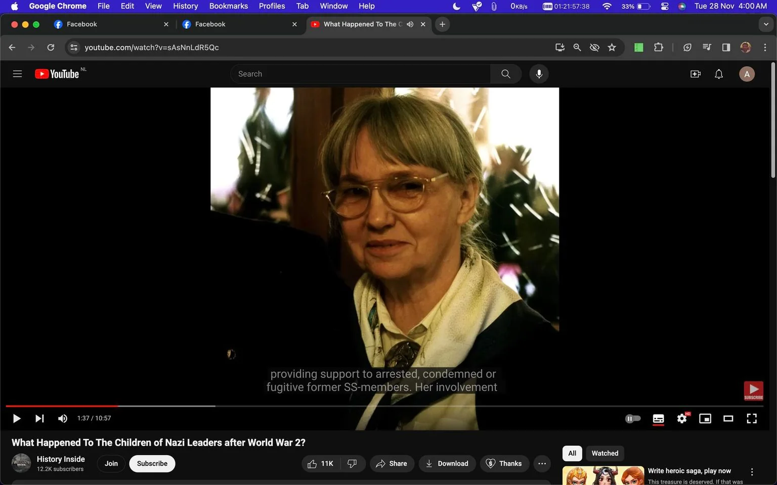The image is a screenshot from a YouTube video titled "What Happened To The Children of Nazi Leaders after World War 2?" The channel hosting the video is "History Inside." The video is paused at 1 minute and 37 seconds, showing a portrait of a woman indoors. She has gray hair pulled back and is wearing glasses, a light-colored blouse, and a scarf. The background is somewhat blurry, featuring plants and reflections, perhaps from a window. The lighting is warm, giving the scene a gentle, reflective atmosphere. The screenshot includes subtitles at the bottom, reading "providing support to arrested, condemned or fugitive former SS-members. Her involvement," suggesting a discussion of historical events related to the children of Nazi leaders. The YouTube interface is visible, with the video controls and related options like "Join," "Share," and "Download."