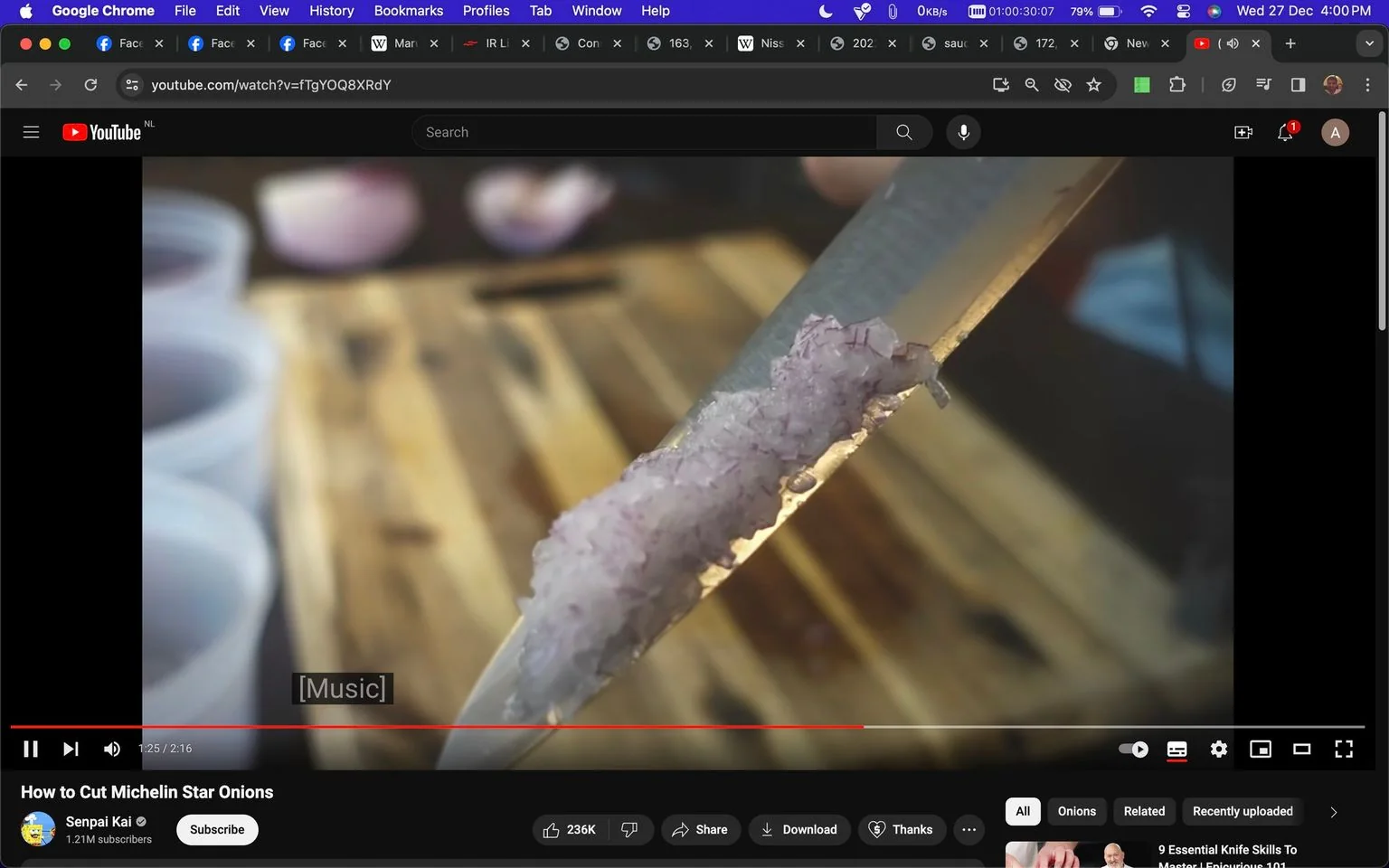 The video frame is from a YouTube tutorial titled "How to Cut Michelin Star Onions" on the channel Senpai Kai. The scene features a close-up of a knife blade with finely chopped onions adhered to it. The focus is sharp on the blade, showcasing the meticulous chopping technique, while the background is slightly blurred, likely showing a cutting board and some out-of-focus kitchen items. The lighting is warm, emphasizing the texture and fineness of the minced onions, suggesting a professional kitchen setting. The video seems to be demonstrating a cooking technique, with the absence of speech indicated by the subtitle "[Music]."
- Title: "How to Cut Michelin Star Onions"
- Channel / profile: "Senpai Kai"
- Site / app: "YouTube"
- Captions / subtitles: "[Music]"