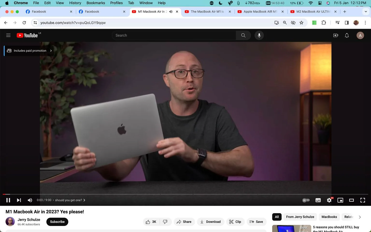The image is a screenshot from a YouTube video titled "M1 Macbook Air in 2023? Yes please!" by Jerry Schulze. It depicts Jerry Schulze, who appears to be conducting a tech review. He is holding a MacBook Air, with the Apple logo clearly visible, suggesting a focus on the product. The setting is indoors with a modern tech-oriented feel, featuring a softly lit background with a lamp and some greenery, adding a casual yet professional ambiance.
Jerry is wearing a dark t-shirt and glasses, and he seems engaged in explaining or discussing the MacBook Air to the audience. The lighting casts a warm tone over the scene, creating an inviting atmosphere. The screenshot captures the paused video at the 0:03 mark, with captions showing "should you get one?" indicating a potential discussion point or focus in the video.
- Title: "M1 Macbook Air in 2023? Yes please!"
- Channel / profile: "Jerry Schulze"
- Site / app: "YouTube"
- Captions / subtitles: "should you get one?"