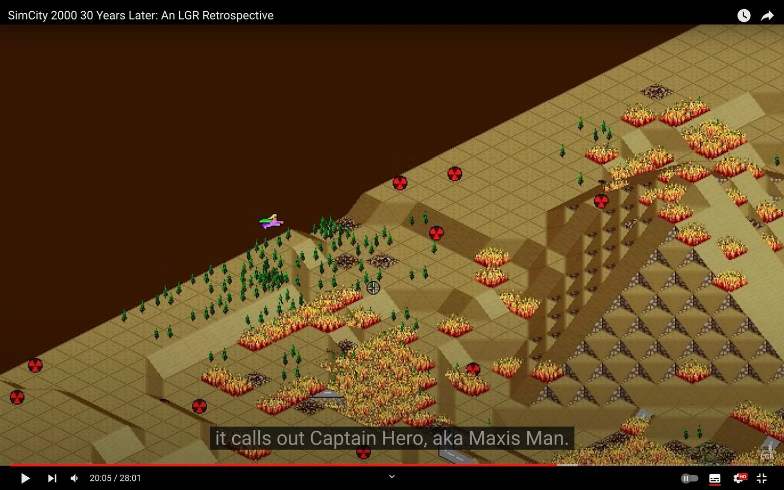 The image is a video frame from a YouTube video titled "SimCity 2000 30 Years Later: An LGR Retrospective" on the LGR channel. It features a gameplay scene from the classic game "SimCity 2000," viewed from an isometric perspective. The landscape consists of a grid with various elevations, including hills and flat terrain. There are numerous fires spread across the landscape, indicated by vibrant orange and red graphics, suggesting a destructive scenario within the game.
A small, colorful sprite resembling an aircraft or superhero figure is visible, possibly representing Captain Hero, aka Maxis Man, as mentioned in the subtitles. The background is a solid brown, typical of the game's borders, while the grid displays a sparse arrangement of trees and symbols, including radiation signs, which hint at a disaster situation. The video appears to be analyzing or revisiting the game, offering insights into its features and impact over time.
- Title: "SimCity 2000 30 Years Later: An LGR Retrospective"
- Channel / profile: "LGR"
- Site / app: "YouTube"
- Captions / subtitles: "it calls out Captain Hero, aka Maxis Man."