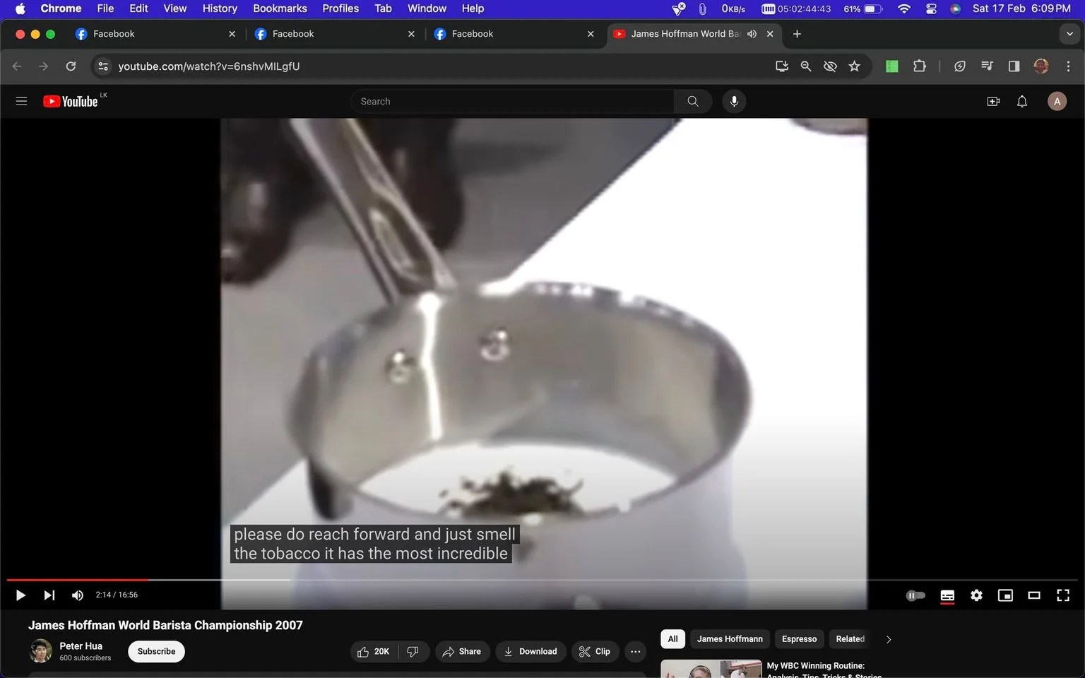 This screenshot is from a YouTube video titled "James Hoffman World Barista Championship 2007," uploaded by the channel Peter Hua. The image captures a close-up shot of a metal pot containing what appears to be a small amount of tobacco. The setting suggests an indoor environment, likely part of a coffee demonstration or competition. The video is related to the World Barista Championship, where James Hoffman is a central figure. The subtitles on the screen read: "please do reach forward and just smell the tobacco it has the most incredible," indicating a part of the demonstration where aroma is emphasized. The visual focus is on the pot, with the background out of focus, highlighting the contents and the apparent action of inviting someone to experience the smell. The scene conveys a professional and detailed atmosphere typical of barista competitions.