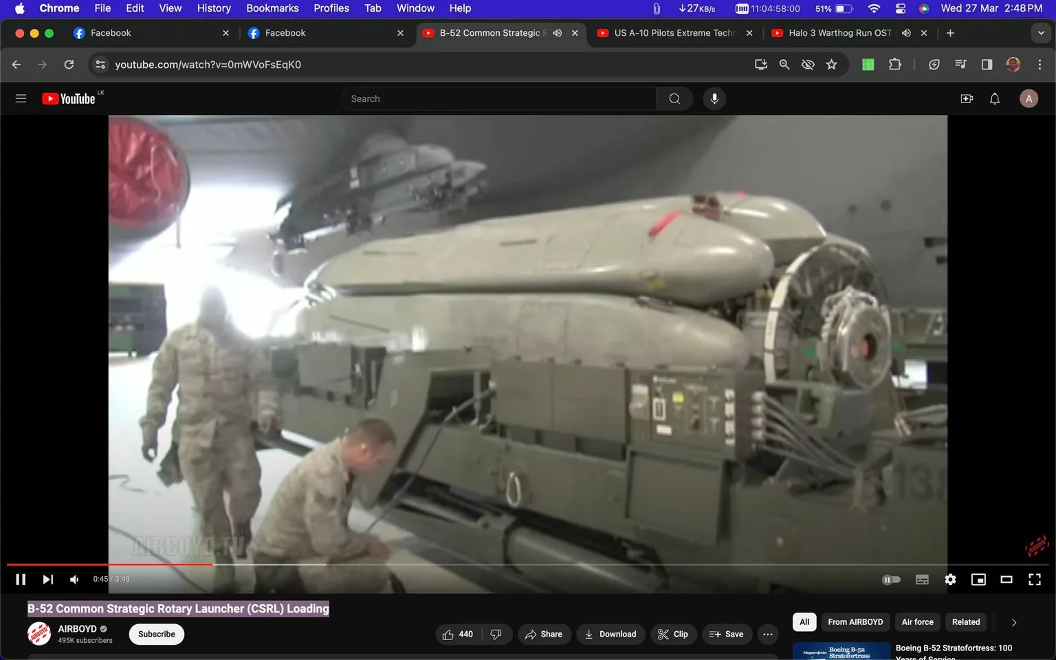 The image is a screenshot from a YouTube video titled "B-52 Common Strategic Rotary Launcher (CSRL) Loading," hosted on the AIRBOYD channel. The scene takes place indoors, possibly in a hangar or aircraft maintenance area. The focus is on military personnel working on a B-52 bomber's rotary launcher, a piece of equipment used to hold and deploy missiles or bombs.
In the foreground, two individuals in military camouflage uniforms are seen, with one kneeling and the other standing. Both are engaged in preparing or inspecting the launcher. This massive piece of machinery is prominently displayed on the right side of the image, showcasing its complex structure, including multiple mounted missiles or bombs with visible red safety tags.
The lighting is bright, illuminating the equipment and personnel clearly. The overall mood is technical and methodical, highlighting the operational aspect of military preparations. The screenshot captures a moment of precision and teamwork, essential for maintaining the functionality of a strategic military aircraft like the B-52.
- Title: "B-52 Common Strategic Rotary Launcher (CSRL) Loading"
- Channel / profile: "AIRBOYD"
- Site / app: "YouTube"