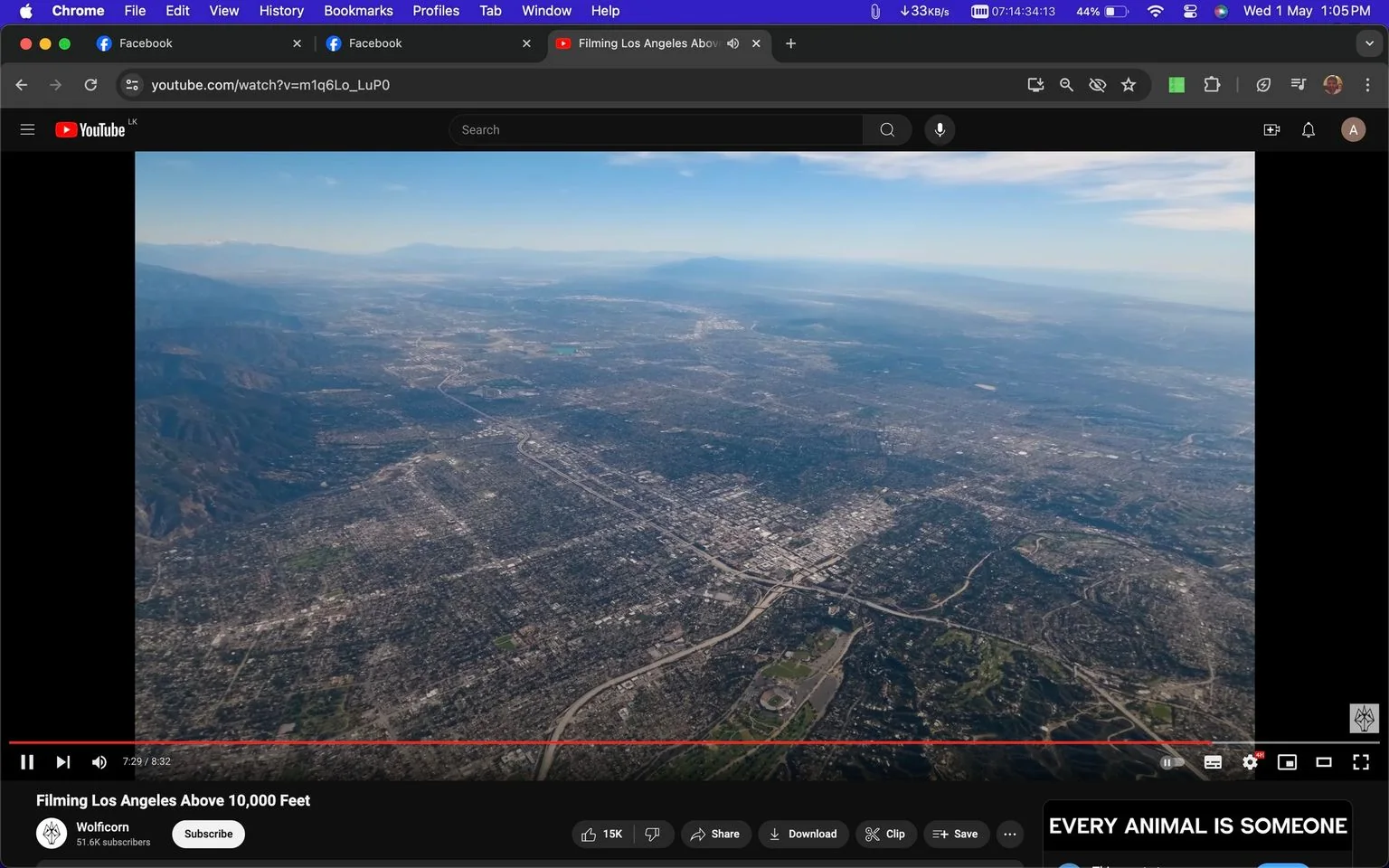 ```
The image is a screenshot from a YouTube video titled "Filming Los Angeles Above 10,000 Feet," presented by the channel Wolfcorn. The video captures a sweeping aerial view of Los Angeles, showcasing the sprawling cityscape under a clear blue sky. The urban grid is densely packed with buildings and intersected by highways, illustrating the vastness and complexity of the metropolitan area. In the foreground and stretching into the background are various neighborhoods, green spaces, and significant infrastructure, including what appears to be a large stadium surrounded by greenery. The landscape transitions smoothly from urban density to the more rugged terrain of surrounding hills and mountains. The lighting suggests it is a clear day, with excellent visibility. The video screenshot also includes on-screen text displaying the phrase "EVERY ANIMAL IS SOMEONE."
- Title: "Filming Los Angeles Above 10,000 Feet"
- Channel / profile: "Wolfcorn"
- Site / app: "YouTube"