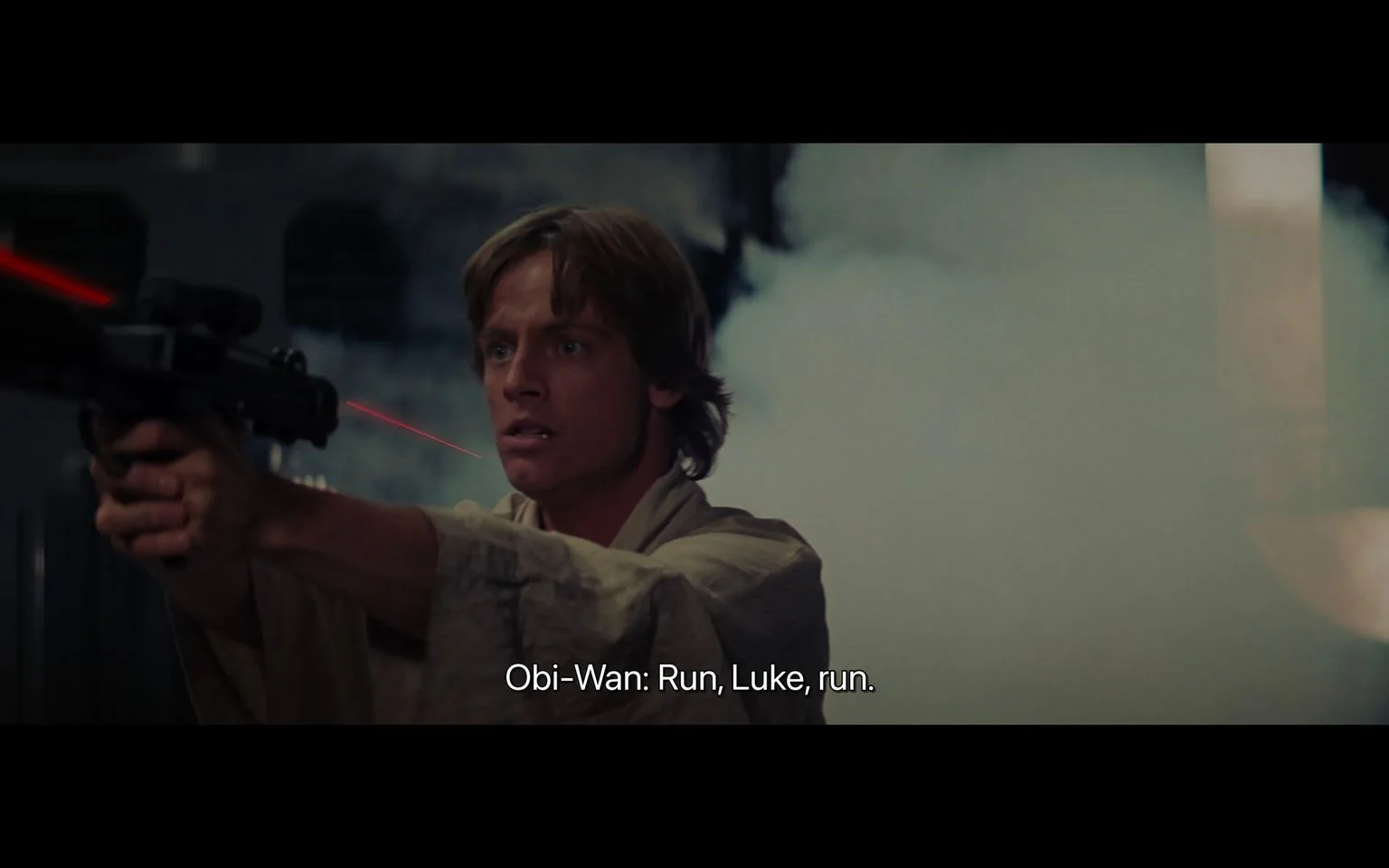 In this intense scene from "Star Wars," a young man is depicted in a moment of high tension. He is holding a blaster with both hands, aiming it forward, his expression a mix of determination and urgency. The background is filled with smoke, enhancing the dramatic atmosphere. The lighting is dim, with shadows accentuating the seriousness of the situation. His attire consists of a light, loose-fitting robe typical of the "Star Wars" aesthetic, suggesting a setting in a galaxy far, far away. The action is highlighted by a red laser beam, indicating a blaster shot in progress. The subtitle at the bottom reads, "Obi-Wan: Run, Luke, run," adding to the urgency and suggesting a critical moment where the character named Luke must make a quick decision. The composition captures a classic sci-fi movie style, with elements that are iconic to the "Star Wars" franchise.
- Captions / subtitles: "Obi-Wan: Run, Luke, run."