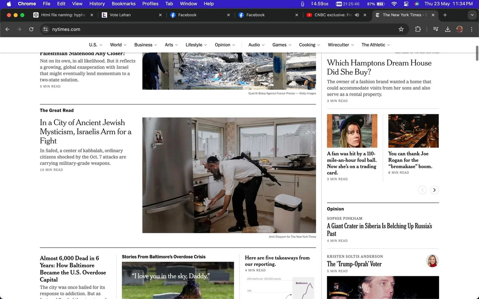 The screenshot captures a section of the New York Times website displayed in a browser window, showing multiple articles with headlines and images. Dominating the center is the headline, "In a City of Ancient Jewish Mysticism, Israelis Arm for a Fight," accompanied by a photo of a man in a kitchen. He is wearing a kippah and has a military-grade weapon slung across his back, indicating heightened tension or preparation for defense. The kitchen appears clean and modern, with a stainless steel refrigerator and white cabinetry, suggesting an ordinary domestic setting juxtaposed with the unusual presence of a weapon.
Adjacent to this article are various other headlines, such as "Almost 6,000 Dead in 6 Years: How Baltimore Became the U.S. Overdose Capital" and "Which Hamptons Dream House Did She Buy?" These headlines cover a range of topics, from real estate to opioid crises, demonstrating the breadth of news content the site provides. The site is clearly identified as nytimes.com at the top of the browser, with navigation links for different sections such as U.S., World, Business, and more. The overall mood is serious and informative, characteristic of a reputable news source.
