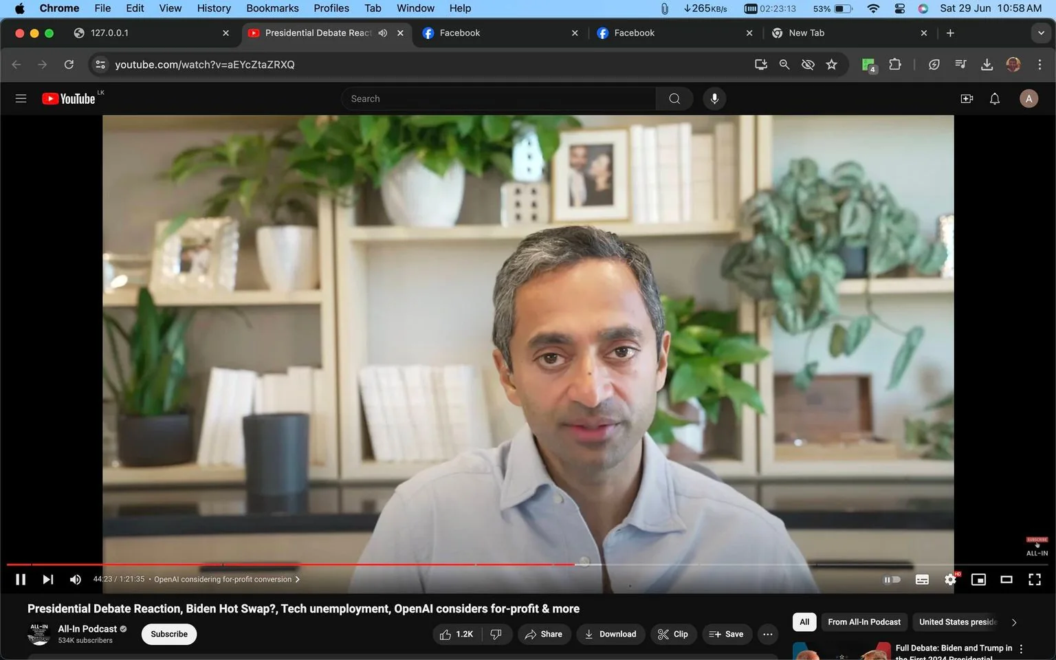 Chamath Palihapitiya is featured in this YouTube video screenshot from the All-In Podcast channel. He is set against a backdrop of stylish shelves adorned with various plants and books, creating a modern and organized ambiance. The lighting is bright and natural, highlighting Chamath's relaxed yet engaged demeanor as he discusses the topics indicated in the video title. He is wearing a light-colored button-up shirt, contributing to the professional yet casual tone of the setting. Notable objects behind him include framed photographs and decorative items, which add a personal touch to the scene. The video appears to cover a range of topics including presidential debate reactions, technological unemployment, and the consideration of for-profit conversion by OpenAI, suggesting a focus on current events and tech industry insights. The video is positioned at the 44:23 mark, indicating Chamath is likely in the midst of an elaborated discussion. The interface shows typical YouTube elements, such as the video title, viewer engagement options, and the channel's subscription count.