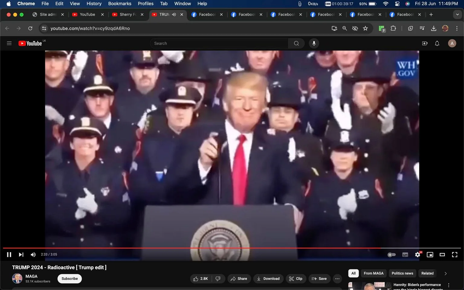 The image is a screenshot from a YouTube video player showing a scene featuring Trump. He is positioned at a podium with the presidential seal visible, suggesting a formal event. Trump is smiling and holding a microphone. He is dressed in a dark suit with a white shirt and a red tie, which stands out against the dark attire of the people surrounding him.
Behind Trump, there is a group of uniformed officers, likely police or firefighters, applauding. They are wearing dark uniforms with caps, some with insignias, and white gloves, adding to the formality of the scene. The background is filled with these uniformed individuals, emphasizing a supportive crowd.
The title of the video is "TRUMP 2024 - Radioactive [Trump edit]" and it is hosted on a YouTube channel named MAGA. The screenshot shows a modern digital interface with various interactive elements such as like, share, download buttons, and a progress bar indicating the video is 2:33 minutes into a total of 3:05. The browser tabs and URL bar suggest this is being viewed on Google Chrome.