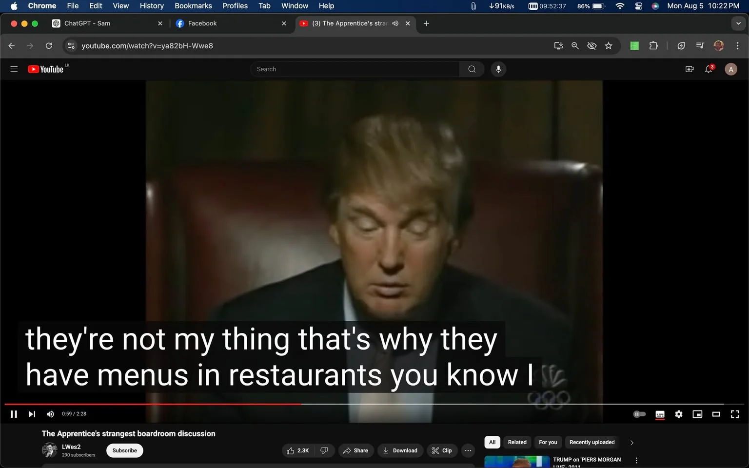 The image is a video frame from a YouTube video titled "The Apprentice's strangest boardroom discussion" on the channel LWes2. It features a scene from "The Apprentice" with Donald Trump. The setting appears to be an indoor boardroom, with dim lighting creating a serious and focused atmosphere. Donald Trump is sitting in a high-backed chair, appearing contemplative or serious, possibly during a moment of decision-making in the show. He is wearing a dark suit and a tie, consistent with the formal setting of the boardroom discussions in "The Apprentice." The frame includes captions at the bottom, displaying the text: "they're not my thing that's why they have menus in restaurants you know I." The YouTube interface is visible, including the browser tabs and video controls. The scene captures the essence of a pivotal or unusual boardroom conversation, typical of the show's dramatic moments. The NBC logo is faintly visible, indicating the network associated with the show.