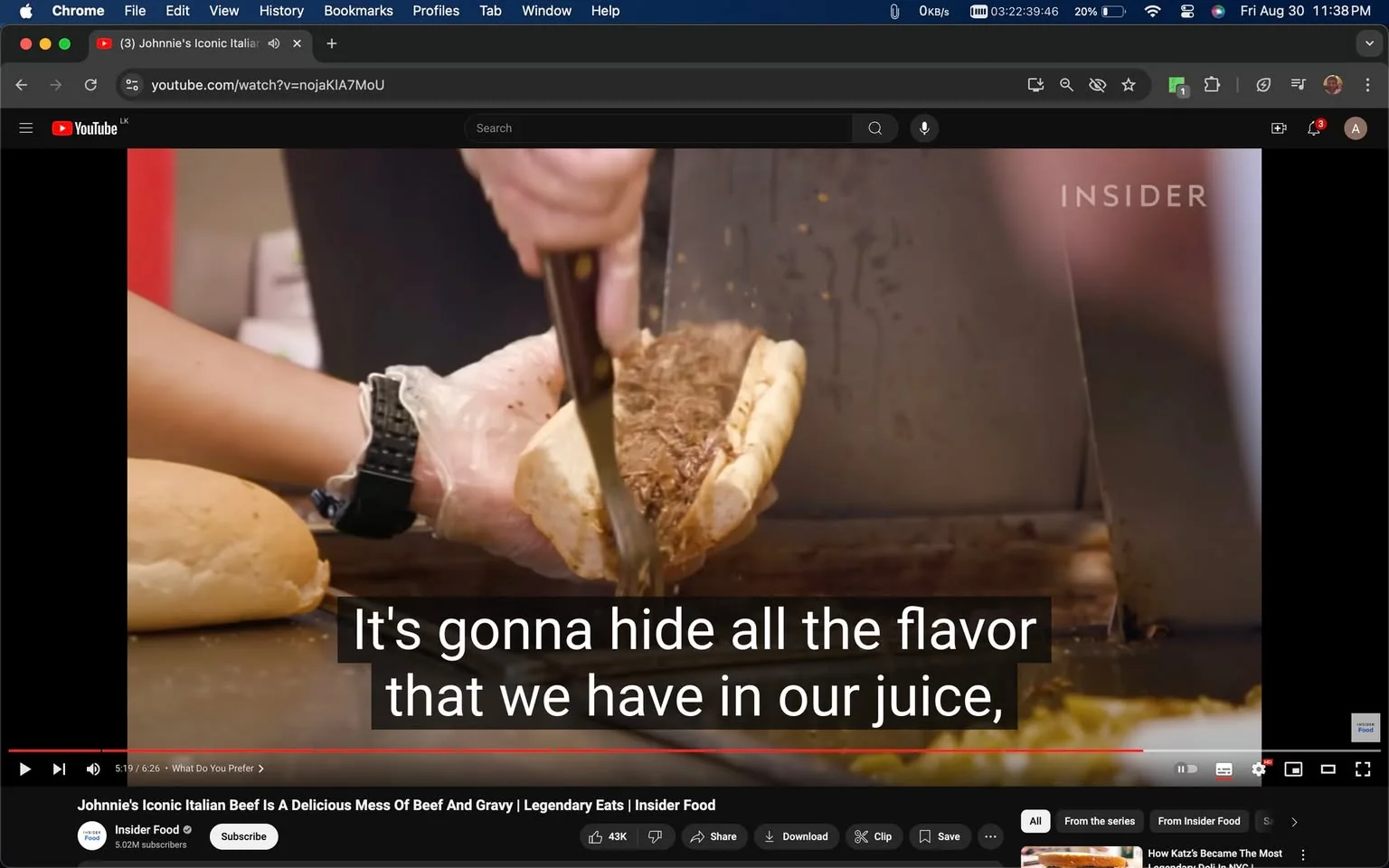 The image is a screenshot from a YouTube video titled "Johnnie's Iconic Italian Beef Is A Delicious Mess Of Beef And Gravy | Legendary Eats | Insider Food" published by the channel Insider Food. The scene depicts a close-up of a person preparing an Italian beef sandwich. The person is wearing a glove on one hand and is using the other hand to hold a knife, slicing into the sandwich, which is filled with juicy beef. The sandwich is placed on a counter, and there is a metal surface in the background, suggesting a kitchen or food preparation area. The lighting is bright, highlighting the textures of the bread and meat. On-screen text is present, with captions reading, "It's gonna hide all the flavor that we have in our juice," indicating a discussion about the cooking process. The scene captures the essence of food preparation, focusing on the technique and ingredients used in making the sandwich. The visual emphasis on the sandwich and the care taken in its preparation highlights its culinary appeal.