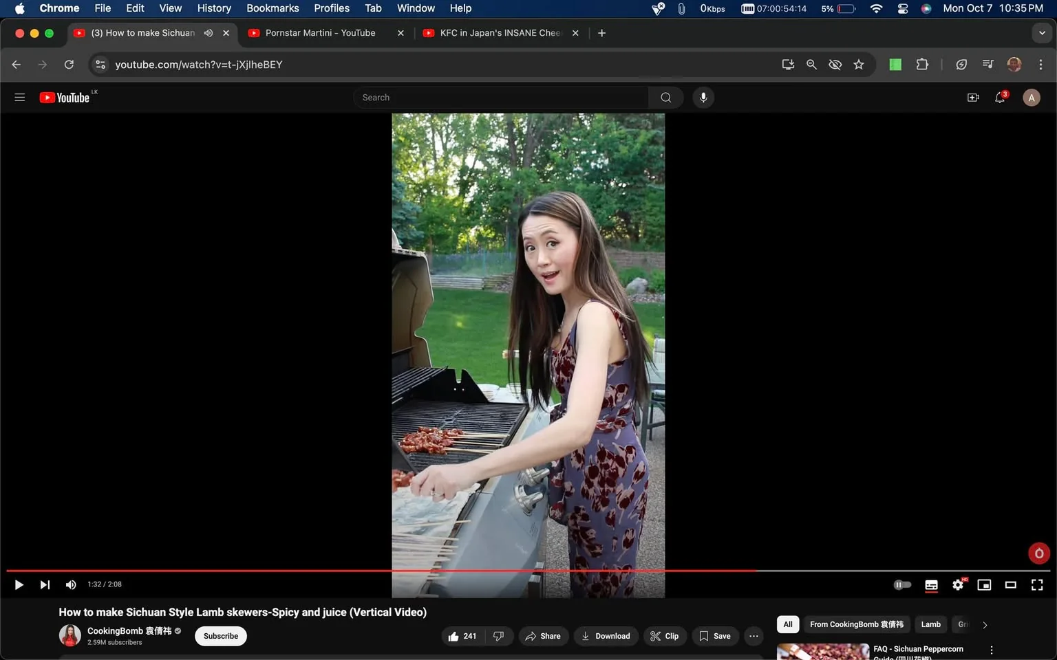 ```
In this YouTube screenshot, a woman is engaging in outdoor cooking, making Sichuan-style lamb skewers. The setting is a sunny backyard with lush greenery in the background, creating a casual and relaxed atmosphere. The woman, described in the hint as resembling a "young, overly dashing julie chung," is using a barbecue grill placed on a patio. She is dressed in a floral-patterned sleeveless dress, appearing focused and a bit surprised or enthusiastic while tending to the skewers on the grill with tongs. The video title, "How to make Sichuan Style Lamb skewers-Spicy and juice (Vertical Video)," suggests a culinary tutorial style, aiming to teach viewers how to make a specific spicy dish. The channel, CookingBomb 爆炸桃, has a significant following with 2.59 million subscribers, indicating its popularity. The composition includes a prominent view of the grill and skewers, with the woman positioned to the right, engaging the viewer directly. This image captures the essence of a lively cooking session, emphasizing the preparation of flavorful, spicy food.
- Title: "How to make Sichuan Style Lamb skewers-Spicy and juice (Vertical Video)"
- Channel / profile: "CookingBomb 爆炸桃"
- Site / app: "YouTube"