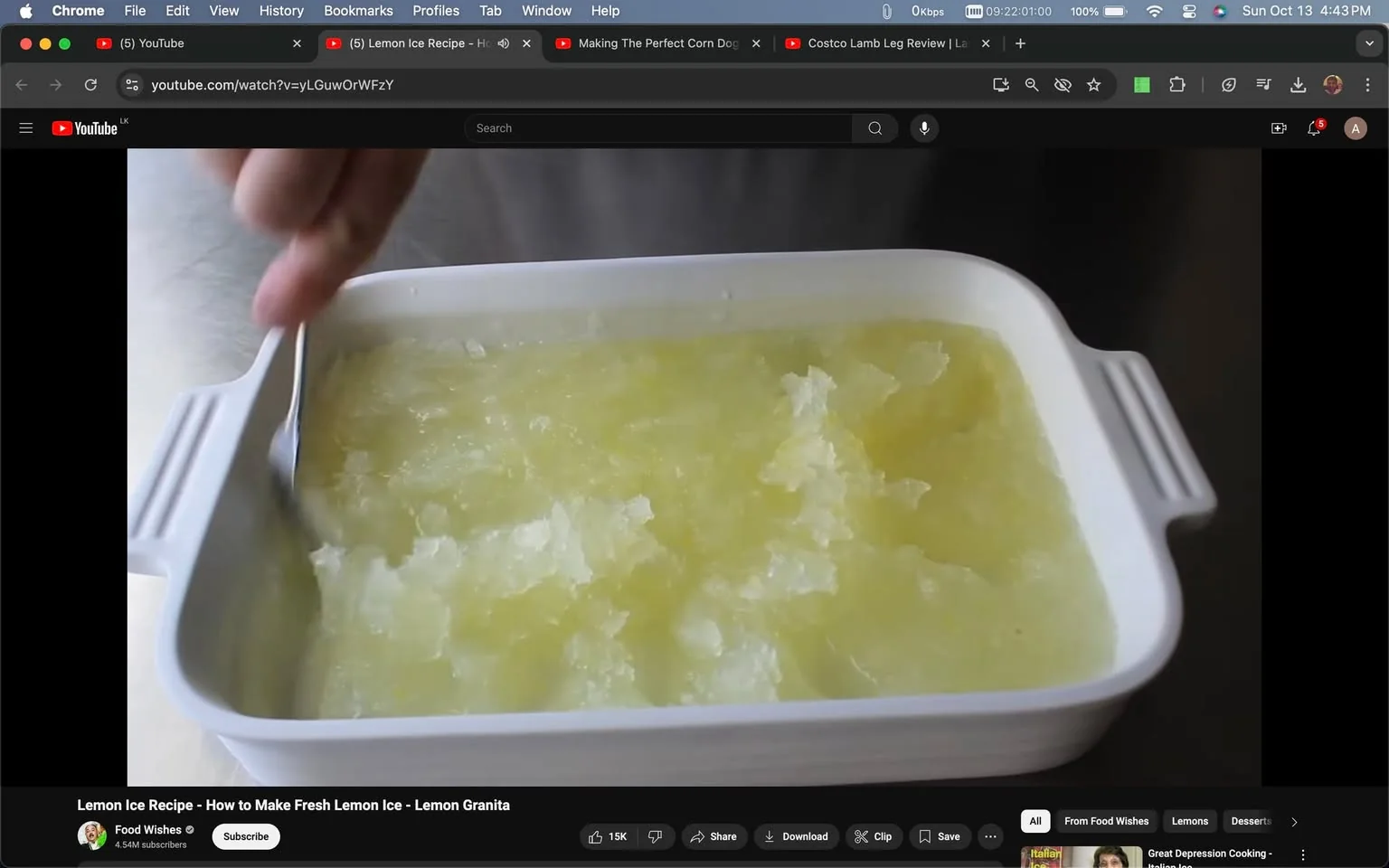 1) Rich description: The video frame shows a close-up of a hand using a fork to scrape a partially frozen lemon mixture in a rectangular white dish. The mixture is being fluffed into a granita-like texture with visible icy shards. The scene is set in a kitchen, with a neutral background, focusing on the preparation process of a lemon granita. The lighting is bright, highlighting the yellowish tint of the frozen dessert, giving it a refreshing and appetizing appearance. The dish’s handles are visible, indicating it's likely designed for baking or cooking. The video, titled "Lemon Ice Recipe - How to Make Fresh Lemon Ice - Lemon Granita," is from the YouTube channel "Food Wishes," which suggests a tutorial style focusing on culinary tips and recipes. The preparation appears simple and the emphasis is on achieving the right texture for the granita, as the hand methodically scrapes the mixture.
2) On-screen text block:
- Title: "Lemon Ice Recipe - How to Make Fresh Lemon Ice - Lemon Granita"
- Channel / profile: "Food Wishes"
- Site / app: "YouTube"