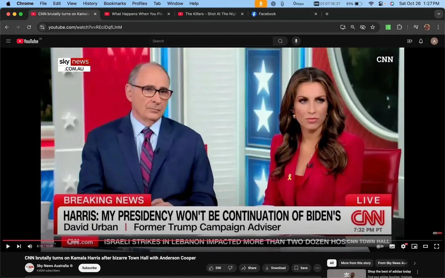 The image is a video frame from a YouTube video titled "CNN brutally turns on Kamala Harris after bizarre Town Hall with Anderson Cooper," published by Sky News Australia. The scene is set in a news studio, featuring two individuals sitting at a news desk, with a large CNN logo in the corner. The person on the left wears a suit with a blue shirt and striped tie, appearing attentive and engaged. The person on the right is wearing a red outfit with long hair, looking focused and serious. Both are seated against a backdrop of stars and stripes, echoing an American patriotic theme.
The on-screen text at the bottom is in a red and white banner, typical for breaking news segments. It reads: "BREAKING NEWS: HARRIS: MY PRESIDENCY WON'T BE CONTINUATION OF BIDEN'S. David Urban | Former Trump Campaign Adviser." Additional text indicates this is part of a "CNN TOWN HALL" broadcast at "7:32 PM PT." The studio lighting is bright, emphasizing the professionalism and seriousness of a live news broadcast.