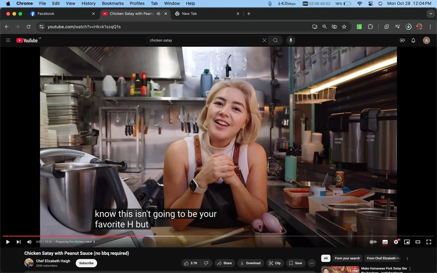 1) Rich description: This screenshot captures a YouTube video titled "Chicken Satay with Peanut Sauce (no bbq required)" from the channel Chef Elizabeth Haigh. The scene is set in a professional kitchen, with Chef Elizabeth Haigh at the center. She leans slightly forward, engaging directly with the viewer, suggesting a casual and approachable atmosphere. The kitchen is well-equipped, with various utensils and ingredients visible, emphasizing that this is a cooking tutorial. Chef Elizabeth is wearing a sleeveless top and an apron, which is typical attire for cooking demonstrations. Her expression is friendly and enthusiastic, indicative of her passion for cooking and sharing recipes. The lighting is bright and even, illuminating the stainless steel surfaces and organized setup around her. In the foreground, a large cooking pot and some sliced ingredients suggest preparation in progress. The subtitles at the bottom of the screen read, "know this isn't going to be your favorite H but," indicating that the chef is in the midst of a conversational segment of the tutorial.
2) On-screen text block:
- Title: "Chicken Satay with Peanut Sauce (no bbq required)"
- Channel / profile: "Chef Elizabeth Haigh"
- Site / app: "YouTube"
- Captions / subtitles: "know this isn't going to be your favorite H but"