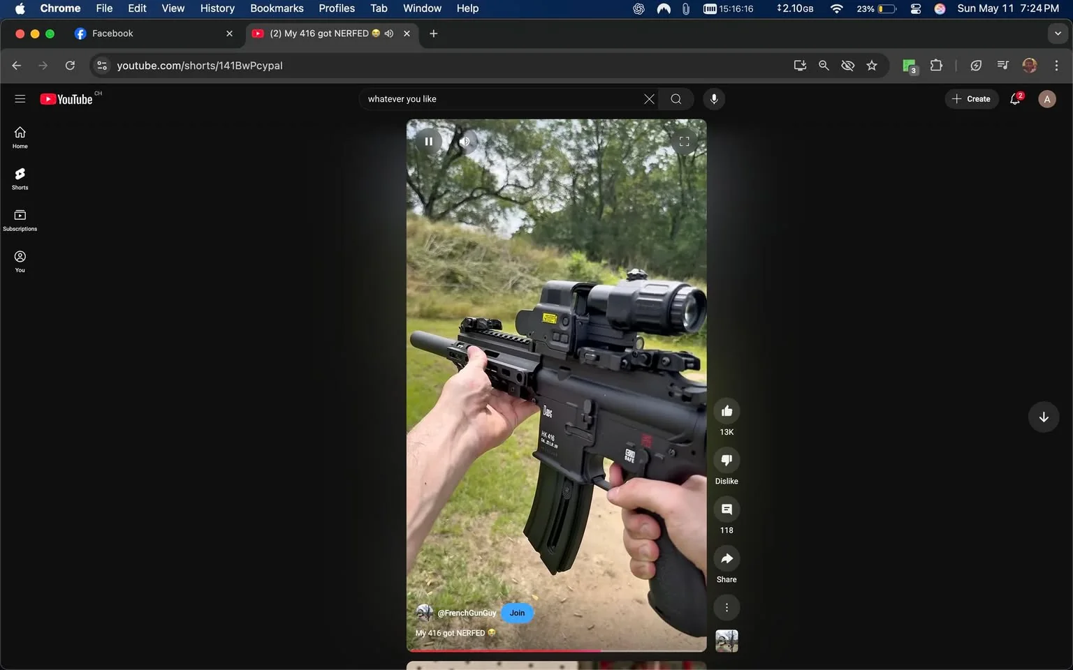 The image depicts a person holding a firearm, specifically an airsoft or replica gun, in an outdoor setting. The firearm appears to be a modern assault rifle style, likely resembling an M4 or similar model. It features a black finish with various attachments. 

1. **Firearm Details**:
   - The gun has a prominent magazine that is curved and black.
   - There is a tactical scope mounted on top, which includes a small flashlight attachment.
   - The body of the gun has several rails for additional accessories.
   - A label or marking is visible on the side of the gun, but the text is not legible in the image.

2. **Person's Appearance**:
   - The individual holding the gun has a light skin tone and is wearing a short-sleeved shirt.
   - Their left hand is gripping the foregrip of the firearm, while the right hand is positioned on the trigger area.
   - The person appears to be focused on aiming or showcasing the weapon.

3. **Background and Setting**:
   - The background features a grassy area with trees and a slight incline, suggesting an outdoor shooting range or recreational area.
   - The ground is a dirt path, indicating a natural environment.

4. **Environmental Context**:
   - The setting appears to be casual and recreational, likely intended for airsoft or shooting practice.
   - There are no visible people in the immediate background, which emphasizes the focus on the individual and the firearm.

5. **Additional Elements**:
   - The image is framed within a digital interface, showing elements typical of a social media platform, including options for liking, sharing, and commenting.

Overall, the image captures a moment of an individual engaging with a firearm in a natural outdoor setting, with a focus on the weapon and the person's handling of it.