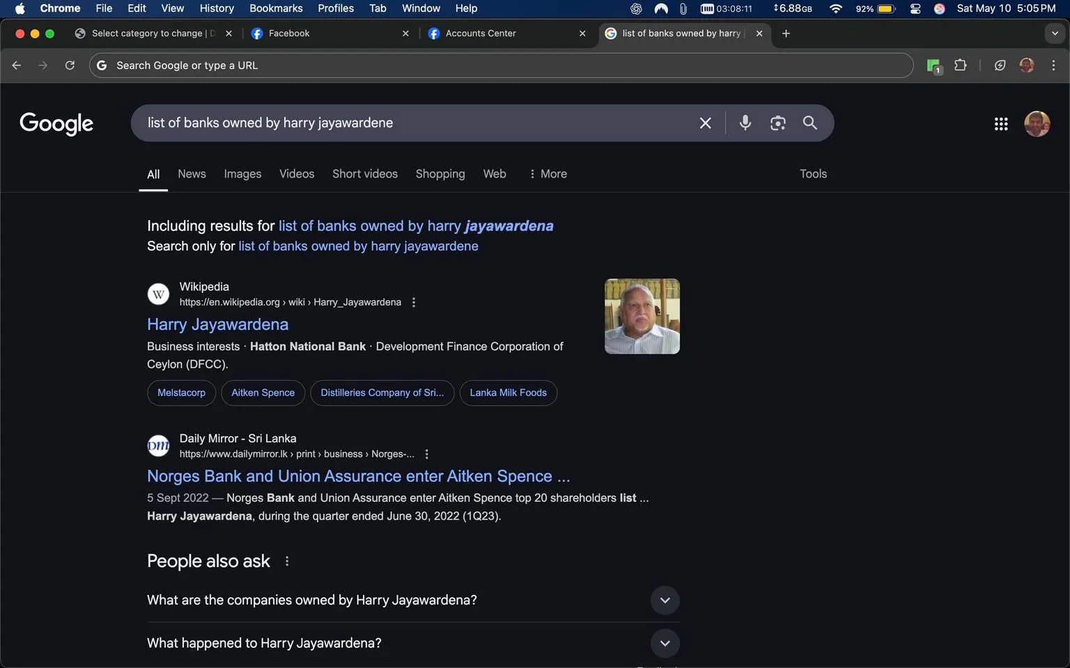 The image displays a Google search results page. The search query at the top reads "list of banks owned by harry jayawardene." The interface is dark-themed, typical of a night mode setting.

1. **Text and Links**: 
   - The first result is from Wikipedia, with the title "Harry Jayawardena." Below it, there is a brief description mentioning his business interests, specifically "Hatton National Bank" and "Development Finance Corporation of Ceylon (DFCC)."
   - There are additional links to companies such as "Melstacorp," "Aitken Spence," "Distilleries Company of Sri Lanka," and "Lanka Milk Foods."
   - The second result is from the Daily Mirror, titled "Norges Bank and Union Assurance enter Aitken Spence," dated September 5, 2022. It mentions Harry Jayawardena in the context of shareholders.

2. **Visual Elements**: 
   - There is a small profile image of a man with a beard and short hair, wearing a light-colored shirt. He appears to be looking directly at the camera.
   - The search results are organized in a list format, with blue hyperlinks leading to various sources.

3. **Background and Context**: 
   - The browser window is open on a Mac computer, indicated by the menu bar at the top, which includes options like "File," "Edit," "View," "History," "Bookmarks," "Profiles," "Tab," "Window," and "Help."
   - The time displayed in the top right corner shows "5:05 PM" on "Saturday, May 10."

4. **Additional Features**: 
   - Below the main search results, there is a section titled "People also ask," which includes questions related to Harry Jayawardena, such as "What are the companies owned by Harry Jayawardena?" and "What happened to Harry Jayawardena?"

Overall, the image captures a typical Google search results page with a focus on Harry Jayawardena and related banking interests.
