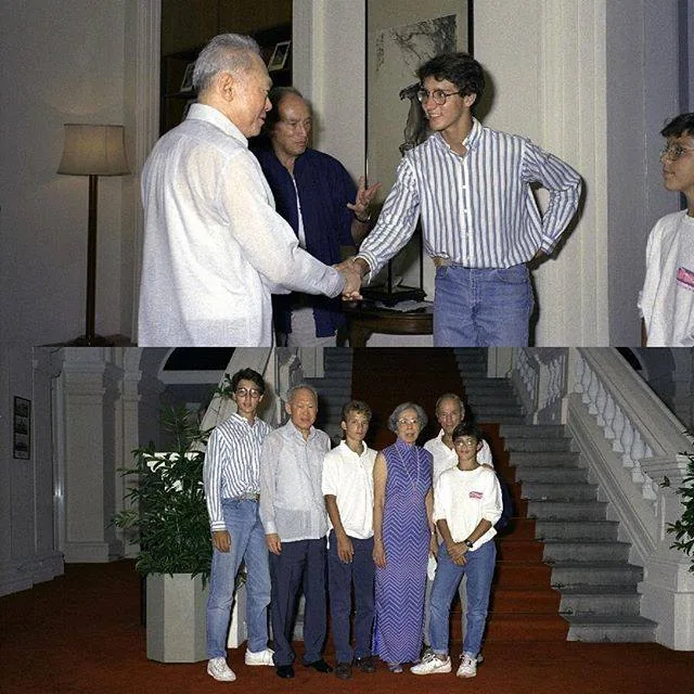 In this image, we see two distinct photographs featuring Lee Kuan Yew and Justin Trudeau. In the top photo, an indoor setting with warm lighting, Lee Kuan Yew is shaking hands with a young Justin Trudeau. Lee Kuan Yew is dressed in a light-colored shirt, while Justin is in a striped shirt and jeans, exuding a casual and youthful appearance. Another man, who appears to be accompanying them, stands slightly behind, observing the handshake.
In the bottom photo, the setting is more formal, with a grand staircase in the background. The group, including Lee Kuan Yew and a woman in a patterned dress, poses for a photo. Justin stands beside them with hands by his side, wearing similar attire. The group is in front of potted plants, suggesting a welcoming environment. The expressions are generally neutral and composed, indicative of a formal meeting or gathering. The red carpet and ornate decor emphasize the formality and significance of the occasion.