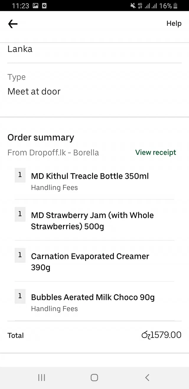 1) Rich description: The image is a screenshot of an order summary from an online delivery service. The order is set to be delivered with a "Meet at door" option. The service provider is listed as "Dropoff.lk - Borella," indicating the location or branch handling the order. Several items are listed, including a 350ml MD Kithul Treacle Bottle, a 500g MD Strawberry Jam with whole strawberries, a 390g Carnation Evaporated Creamer, and a 90g Bubbles Aerated Milk Choco. The total cost of the order is displayed as 1579.00 Sri Lankan Rupees, with the currency sign "රු" before the amount. The overall layout is clean, with text organized in a straightforward and easy-to-read manner. The text is primarily in black on a white background, following a typical minimalist design of order summary displays. The battery icon at the top right indicates the device's charge is at 16%, and the network connection is 4G. The settings and help options are available at the top of the screen, typical for an app interface.
2) On-screen text block:
- Title: "Order summary"
- Key text: "Lanka", "Meet at door", "From Dropoff.lk - Borella", "MD Kithul Treacle Bottle 350ml", "MD Strawberry Jam (with Whole Strawberries) 500g", "Carnation Evaporated Creamer 390g", "Bubbles Aerated Milk Choco 90g", "Total", "රු1579.00"