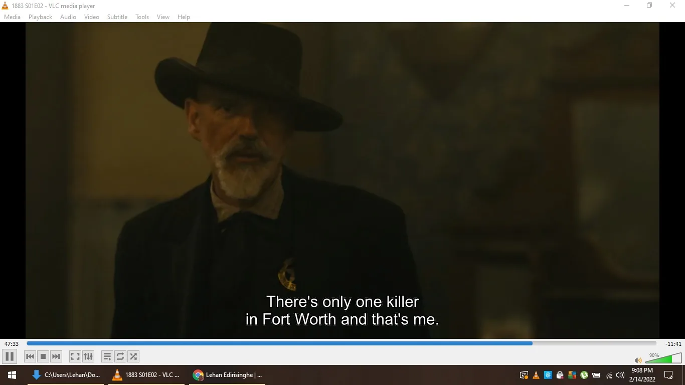 In this image, the scene is from the television series "1883," featuring Sheriff Jim Courtright, played by Billy Bob Thornton. The character is depicted indoors, enveloped in a dramatic and tense atmosphere. He sports a dark hat with a wide brim and a matching suit, projecting an authoritative and rugged demeanor typical of Western dramas. The lighting is dim, highlighting his serious expression as he declares, "There's only one killer in Fort Worth and that's me," underscoring his formidable presence. The video's interface indicates it is being played on VLC media player, with the progress bar and media controls visible at the bottom. This setting and the character's attire contribute to the historical and dramatic tone of the series, immersing the viewer in the gritty world of the American frontier.