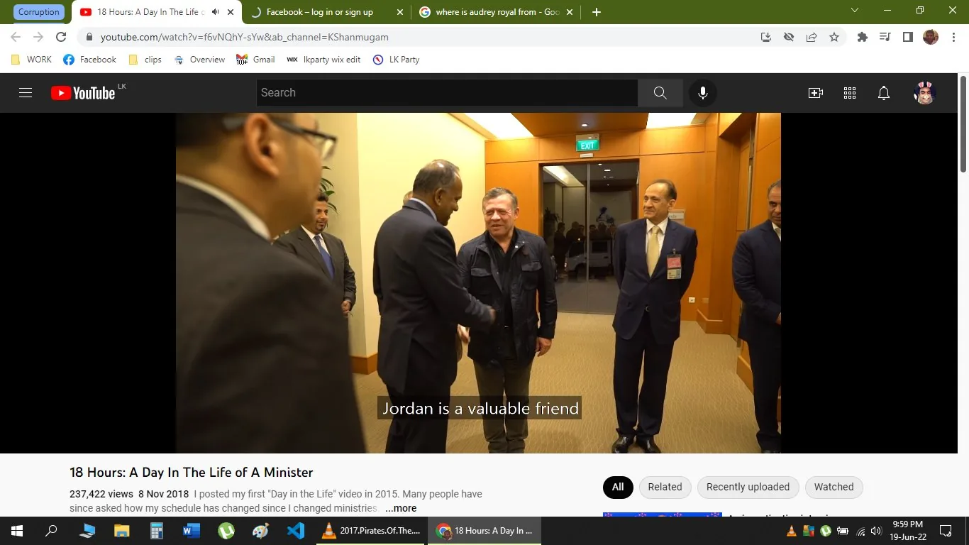 The image is a video frame from a YouTube video titled "18 Hours: A Day In The Life of A Minister" on the channel KShanmugam. The scene takes place indoors in a formal setting, possibly an office or conference room. The lighting is bright, and the walls are a warm, light brown color, giving a professional and welcoming atmosphere.
In the foreground, two men are engaged in a handshake, indicating a gesture of diplomacy and friendship. One of the men, based on the user hint, is K Shanmugam. They are both dressed in formal attire; K Shanmugam is likely in a suit, reflecting the formality of the occasion. There are other individuals in the background, all dressed in suits, suggesting a meeting or diplomatic event.
The subtitle "Jordan is a valuable friend" is visible, implying a discussion related to international relations. The mood appears cordial and respectful, with the participants' expressions focused and engaged. This visual captures a moment of diplomatic interaction, emphasizing the themes of friendship and collaboration between nations.