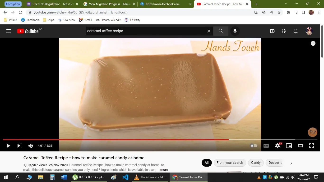 The screenshot shows a YouTube video titled "Caramel Toffee Recipe - how to make caramel candy at home" by the channel "Hands Touch." The video is paused at 4:01 of a total duration of 5:35. The main visual is a smooth, glossy sheet of caramel toffee placed on a piece of parchment paper on a wooden surface. The toffee appears freshly made, with a rich, golden-brown color and a slightly shiny texture, indicating its sticky and chewy nature. The background is simple and minimal, focusing the viewer's attention on the toffee itself. The video has over a million views and was published on November 25, 2020. The text "Hands Touch" is written in a cursive style at the upper right corner of the video, adding a personal touch to the presentation. The scene suggests an indoor kitchen setting, likely part of a step-by-step cooking guide.
- Title: "Caramel Toffee Recipe - how to make caramel candy at home"
- Channel / profile: "Hands Touch"
- Site / app: "YouTube"