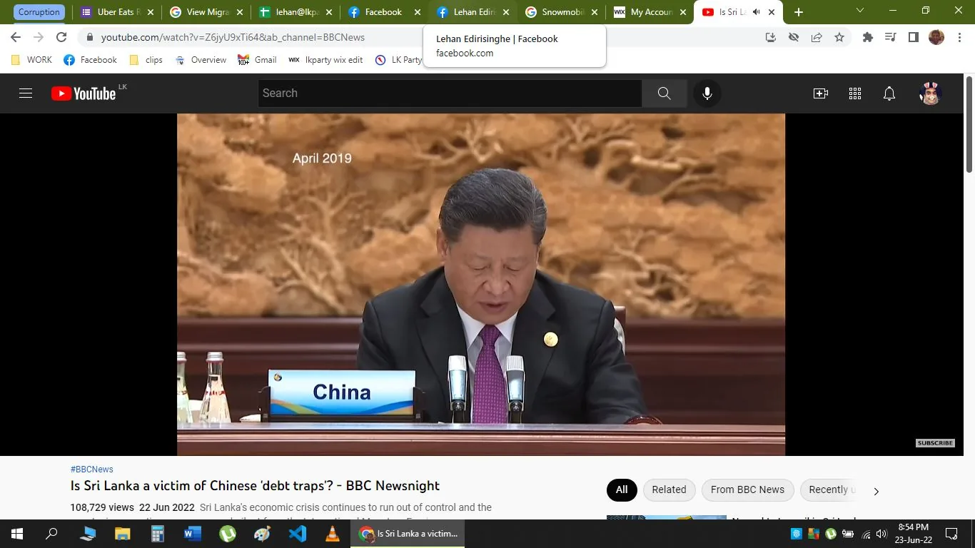The image is a screenshot from a YouTube video titled "Is Sri Lanka a victim of Chinese 'debt traps'? – BBC Newsnight," published by BBC News. The scene features Xi Jinping, identified through the hint, seated at a conference table. He appears to be delivering a speech or addressing an audience, with a serious and focused expression. The setting seems formal, with a polished wood table and a backdrop featuring intricate patterns in warm tones, suggesting a decorative wall or tapestry.
A nameplate reading "China" is prominently placed in front of Xi Jinping, along with two microphones, indicating that he is likely at an official international conference or summit. The image includes the text "April 2019," suggesting the time of the event. Xi Jinping is dressed in a dark suit, a white shirt, and a tie, reinforcing the formal nature of the occasion. The video is accessible on the YouTube platform, focusing on the economic relationship and debt issues between Sri Lanka and China.