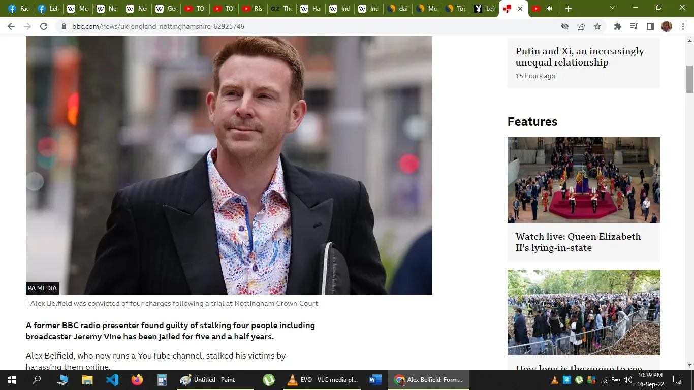 A man believed to be Alex Belfield is depicted in this outdoor image, dressed in a dark blazer and a colorful, patterned shirt. He appears to be holding a folder or document case, suggesting a formal or legal context, possibly linked to the mention of Nottingham Crown Court. The background is out of focus, with hints of urban scenery, indicating the setting is likely outside a courthouse. The lighting is natural, suggesting daytime.
The screenshot is from a BBC News article titled "Alex Belfield: Former BBC DJ jailed for stalking Jeremy Vine," which discusses Belfield's conviction for stalking multiple individuals, including broadcaster Jeremy Vine. The page layout includes a main image of Belfield, with additional articles and features listed on the right side, including topics like Queen Elizabeth II's lying-in-state. The overall tone of the article is serious, focusing on legal proceedings and crime.
- Title: "Alex Belfield: Former BBC DJ jailed for stalking Jeremy Vine"
- Site / app: "bbc.com"