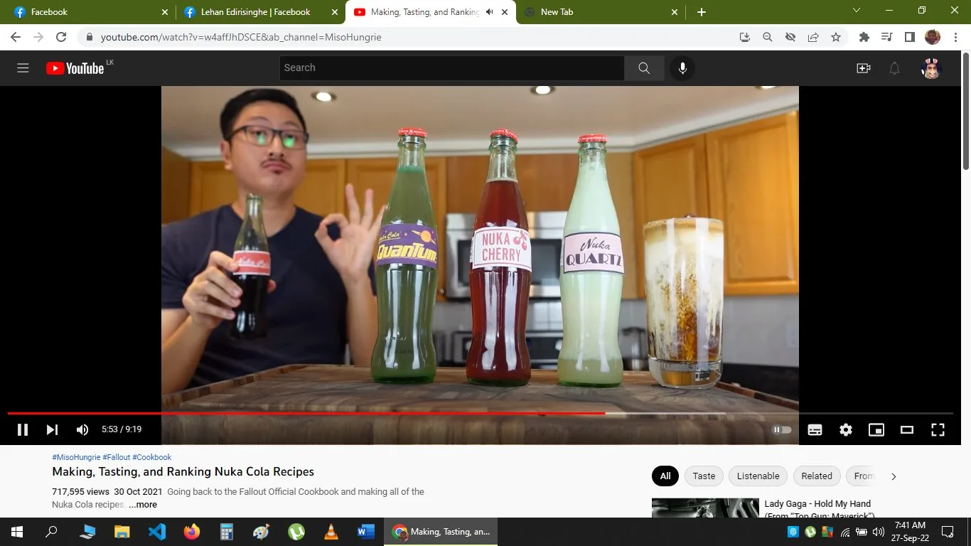 The image is a screenshot from a YouTube video titled "Making, Tasting, and Ranking Nuka Cola Recipes," featured on the channel MisoHungrie. The video appears to be about recreating beverages from the "Fallout Official Cookbook." The setting is a kitchen with wooden cabinets in the background, suggesting a casual and homey atmosphere. Four glass bottles are prominently displayed on a table, each labeled with a unique "Nuka Cola" variant: "Quantum," "Nuka Cherry," and "Nuka Quartz," among others. The bottles have colorful labels, adding a playful touch to the scene.
A person is seated behind the table, holding a bottle of "Nuka Cola" and making an "OK" gesture with their other hand, suggesting approval or satisfaction. The person wears glasses and a dark shirt, and their expression appears enthusiastic, contributing to the engaging vibe of the video. To the side, a frothy drink is seen in a glass, further indicating the tasting theme. The video is paused at 5:53 out of a total duration of 9:19. The screenshot also includes typical YouTube elements like the video title, view count, and upload date, providing context for viewers interested in video game-themed culinary creations.