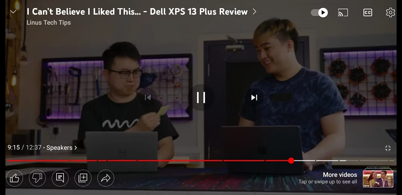 The scene is set indoors, likely in a studio designed for tech reviews. Two individuals are sitting at a table with laptops in front of them. They are engaged in a discussion, as indicated by their facial expressions and postures. The atmosphere is casual and relaxed, typical of a tech review video. The person on the left is wearing glasses and a black shirt, holding a small object, possibly a tool or component, and looking at it thoughtfully. The person on the right is smiling, wearing a patterned blue shirt, suggesting a light-hearted interaction.
The background features a well-organized tech setup, with pegboards displaying various tools and computer components, illuminated by ambient purple lighting. The setting is modern and tech-oriented, highlighting the theme of the video, which is a review of the Dell XPS 13 Plus laptop. The overall lighting is bright, ensuring the subjects and their expressions are clearly visible.
- Title: "I Can’t Believe I Liked This… – Dell XPS 13 Plus Review"
- Channel / profile: "Linus Tech Tips"
- Site / app: "YouTube"