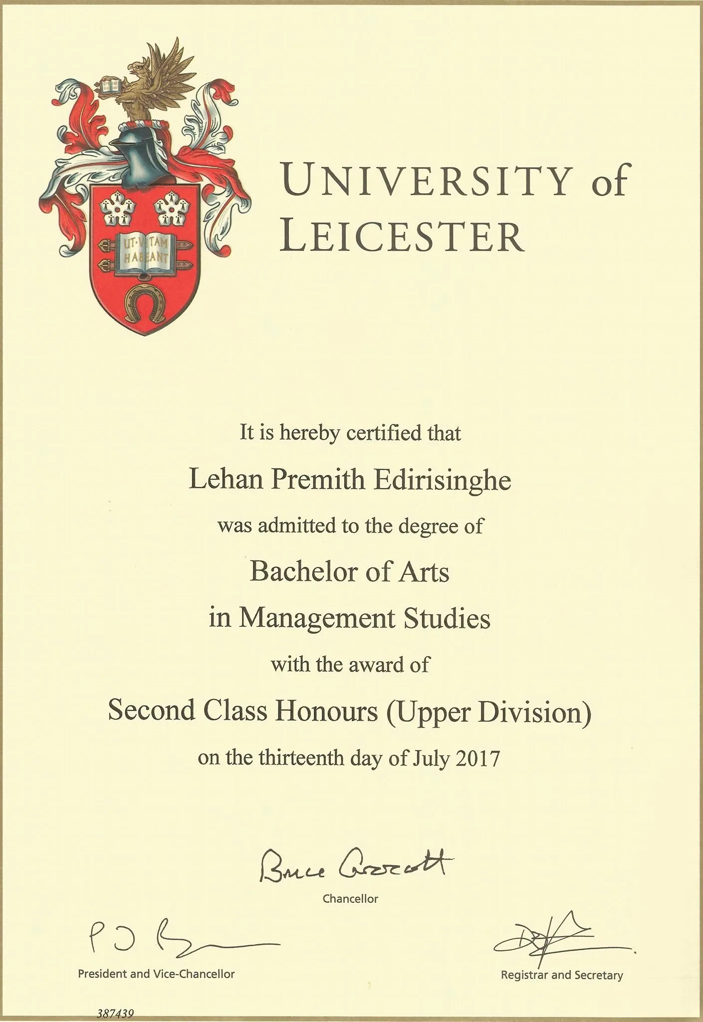 The image shows an official degree certificate from the University of Leicester. It certifies that Lehan Premith Edirisinghe was awarded a Bachelor of Arts in Management Studies with Second Class Honours (Upper Division) on July 13, 2017. The certificate features the university's crest prominently on the left side, which includes a shield with decorative elements and a mythical creature. The text is elegantly formatted, primarily using serif fonts, which lend a formal and official appearance to the document.
Signatures of the Chancellor, President and Vice-Chancellor, and the Registrar and Secretary are visible at the bottom, indicating authenticity. The document number "387439" is printed at the bottom left, which might be used for identification or record-keeping purposes. The certificate is designed on a light, neutral background, which enhances readability and highlights the text and crest. This type of document is typically stored in a portfolio or frame for display, reflecting academic achievement and recognition.