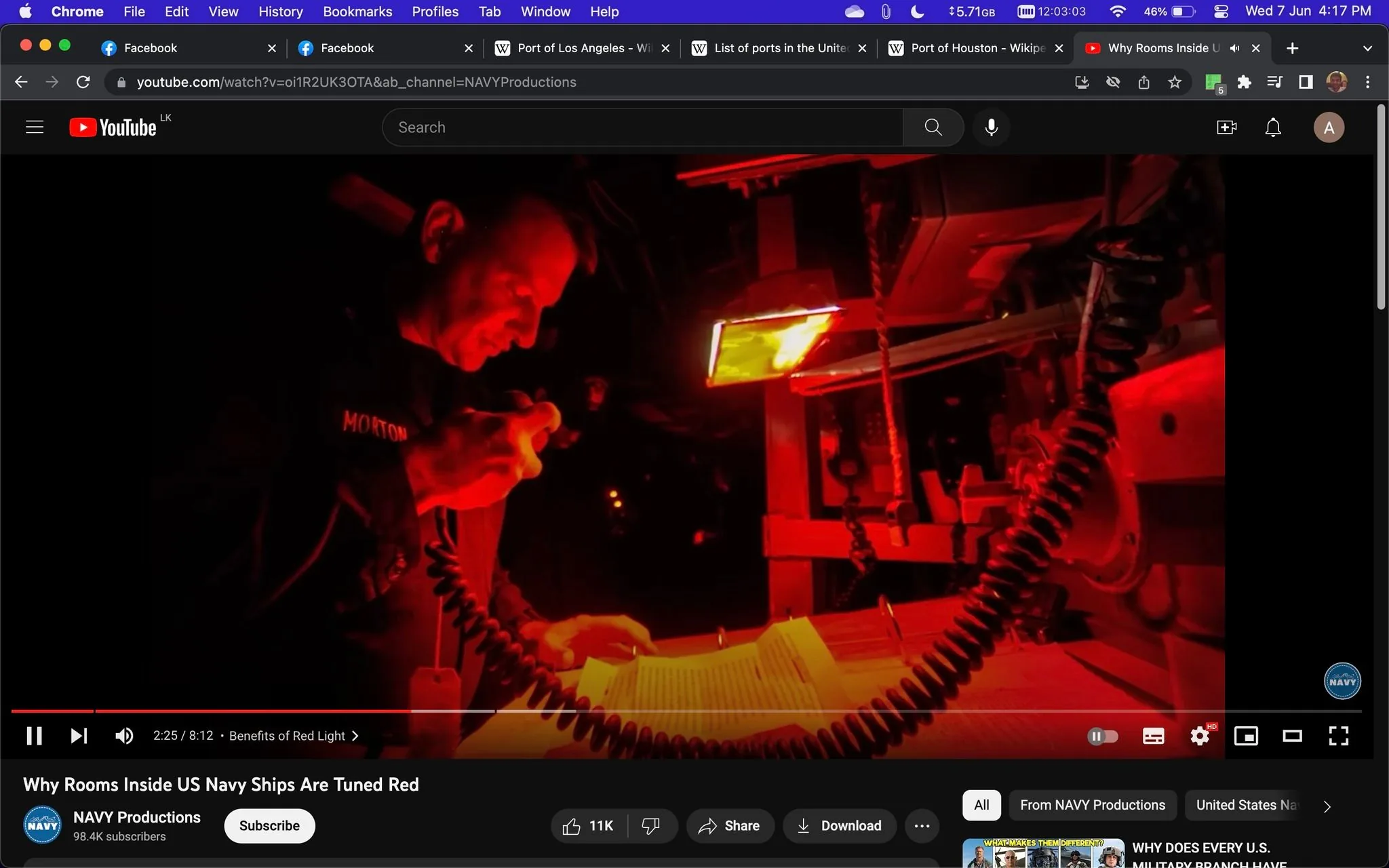 1) Rich description (8–12 sentences): This image is a screenshot from a YouTube video titled "Why Rooms Inside US Navy Ships Are Tuned Red," published by NAVY Productions. It shows a scene inside a room on a US Navy ship that is illuminated with red lighting. In the foreground, a person is using a handheld microphone, appearing to communicate through a device. They are standing next to a table with what looks like operation manuals or documents spread out. The red lighting casts a strong hue over the entire scene, creating a high-contrast atmosphere that emphasizes the importance and seriousness of the setting. The person is wearing a dark uniform with a name tag visible, though the name itself is not clear. The background contains additional equipment and wires, contributing to the technical and operational environment typical of a ship's control room. The use of red light, as explained in the video, is likely for preserving night vision while still allowing for visibility in the space. The overall mood is focused and purposeful, with the red light adding a distinct military feel to the environment.
2) On-screen text block (only include lines that have real text; if a field is unknown or blank, omit that line entirely):
- Title: "Why Rooms Inside US Navy Ships Are Tuned Red"
- Channel / profile: "NAVY Productions"
- Site / app: "YouTube"
- Captions / subtitles: "Benefits of Red Light"