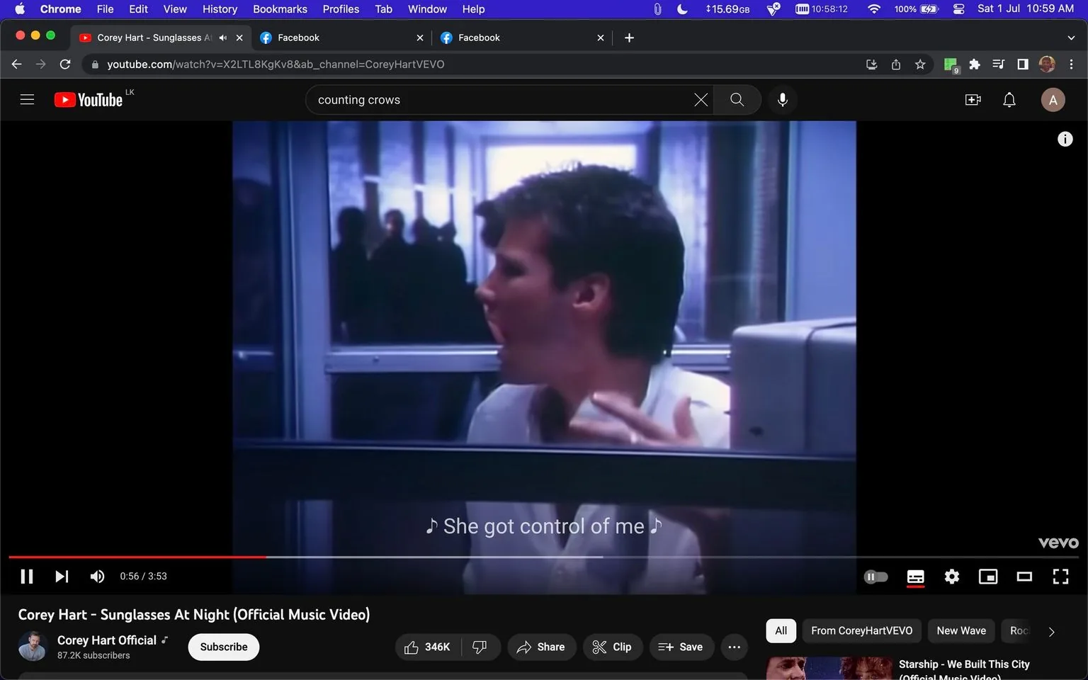 The image is a video frame from the official music video for "Sunglasses At Night" by Corey Hart, as indicated by the title. The video is hosted on YouTube, and the channel is "Corey Hart Official," under the publisher "CoreyHartVEVO." The scene shows a man, presumably Corey Hart, in a room with glass walls, possibly an office or a studio. He appears to be singing, with his mouth open and one hand raised slightly. The lighting is dim, suggesting an indoor setting with artificial light. The subtitle on the screen reads "She got control of me," indicating a part of the song's lyrics. In the background, silhouettes of people can be seen through the glass, adding depth to the composition. The overall mood is introspective and dramatic, fitting the theme of the song.
- Title: "Corey Hart - Sunglasses At Night (Official Music Video)"
- Channel / profile: "Corey Hart Official"
- Site / app: "YouTube"
- Captions / subtitles: "She got control of me"