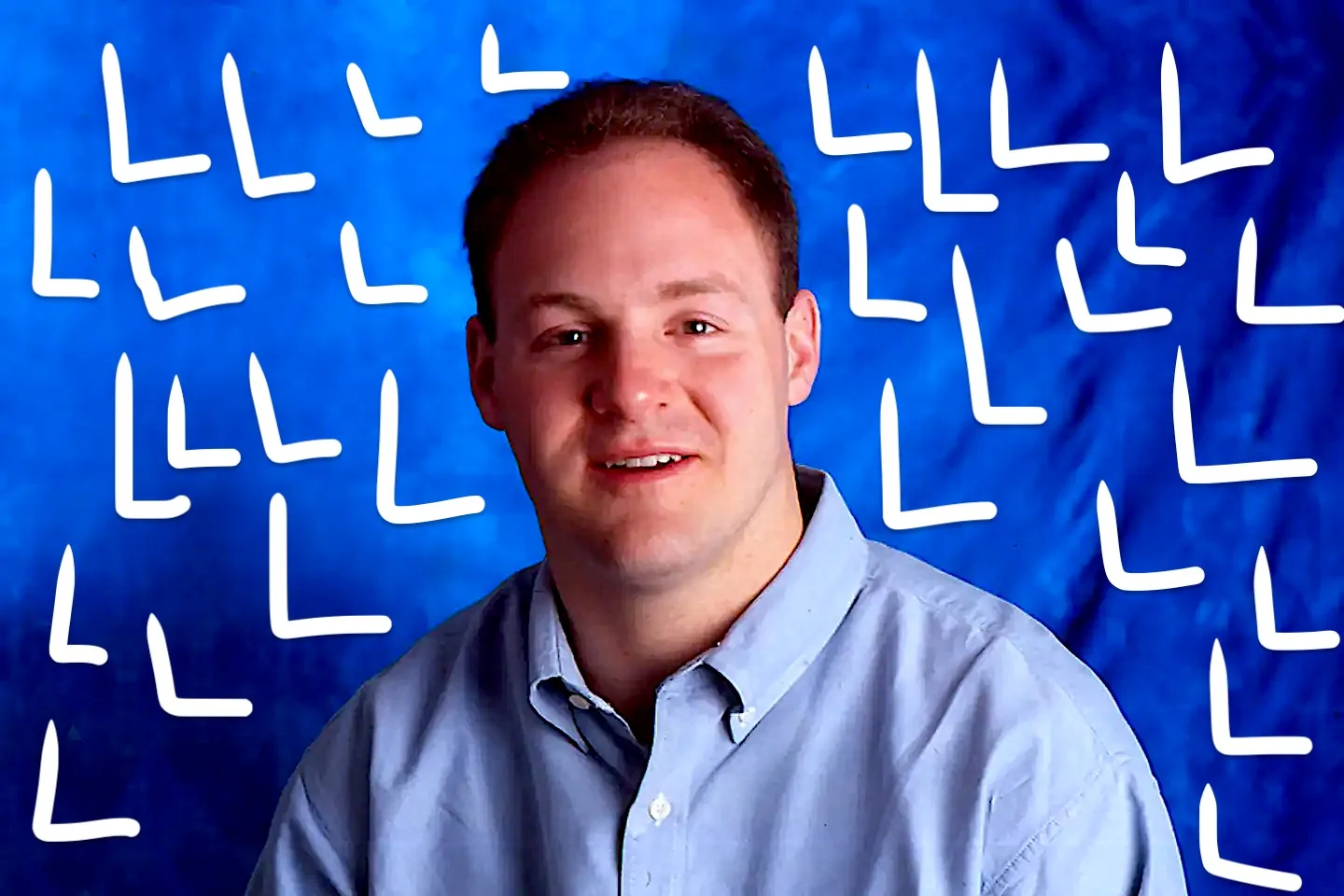 Danny Lewin is depicted in this portrait-style image. He is wearing a light blue button-up shirt and is set against a vibrant blue background. The background is adorned with a pattern of white "L" shapes, adding a dynamic visual element to the composition. The lighting is bright and evenly distributed, highlighting Lewin's face and attire. His expression is pleasant and approachable, suggesting a sense of calm and confidence. The overall style is clean and professional, typical of a studio portrait. The lack of additional objects or text emphasizes the focus on Lewin himself within this image.