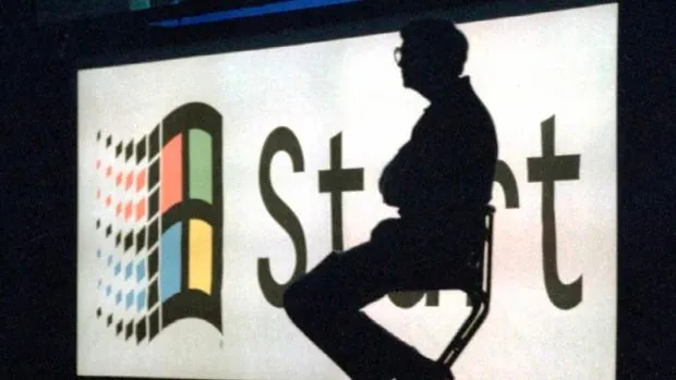 The image shows a prominent silhouette of a person identified as Bill Gates, seated on a stool against a large backdrop. This backdrop features the iconic Windows logo with colorful, waving panes and the word "Start" in large text beside it. The setting appears to be indoors, likely during a presentation or launch event, given the context and prominent display of branding associated with Microsoft Windows. The lighting creates a dramatic effect, casting the person as a shadowy figure, which emphasizes the importance of the backdrop and the Windows branding. The composition places the person slightly off-center, adding to the sense of anticipation and focus on the product being highlighted. The overall mood is one of innovation and technology, characteristic of a major software release event. The setting is professional, likely capturing a moment from a significant public appearance or announcement related to Microsoft.
- Title: "..."