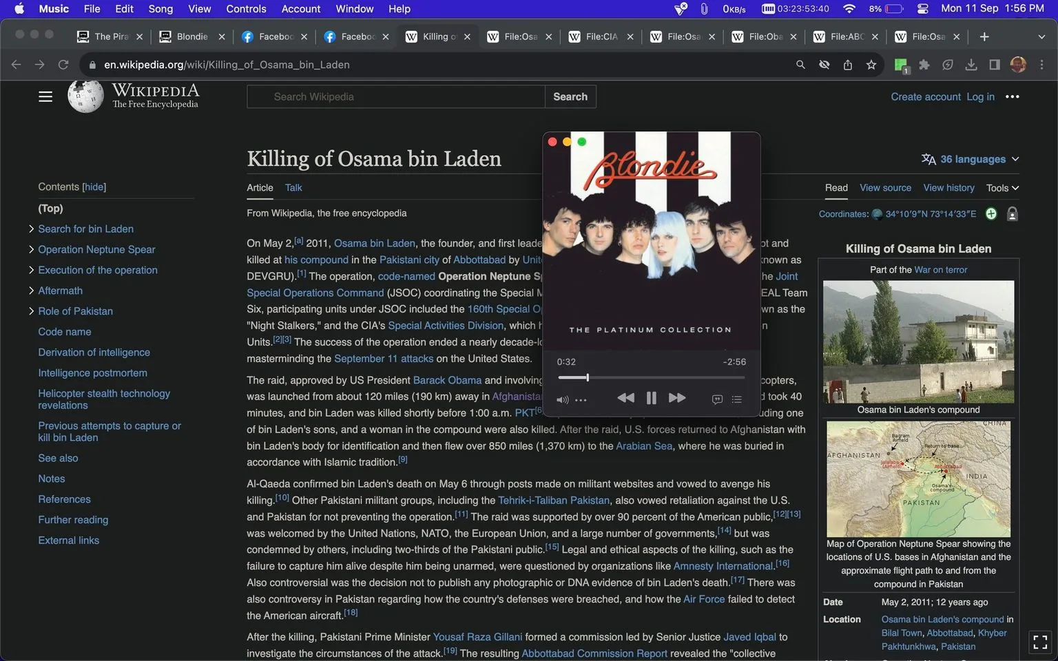 The image is a screenshot of a Wikipedia article titled "Killing of Osama bin Laden." The article discusses the events surrounding the death of Osama bin Laden on May 2, 2011, in Abbottabad, Pakistan, by United States forces. The main text describes the operation, code-named Operation Neptune Spear, orchestrated by the Joint Special Operations Command. The top-left section shows the contents list with sections like "Search for bin Laden" and "Aftermath," while the right side features a photograph of Osama bin Laden's compound and a map detailing the operation's location.
Overlaying the Wikipedia article is a music player displaying an album cover of the band Blondie titled "The Platinum Collection." The music player shows a song currently playing, with a progress bar indicating 32 seconds into the track. The interface is typical of digital music players, showing play/pause and skip controls.
The screenshot captures a dark-mode interface of the website, with white text against a black background, creating a high-contrast visual. Tabs and a search bar are visible at the top of the browser window, indicating a typical web browsing environment.