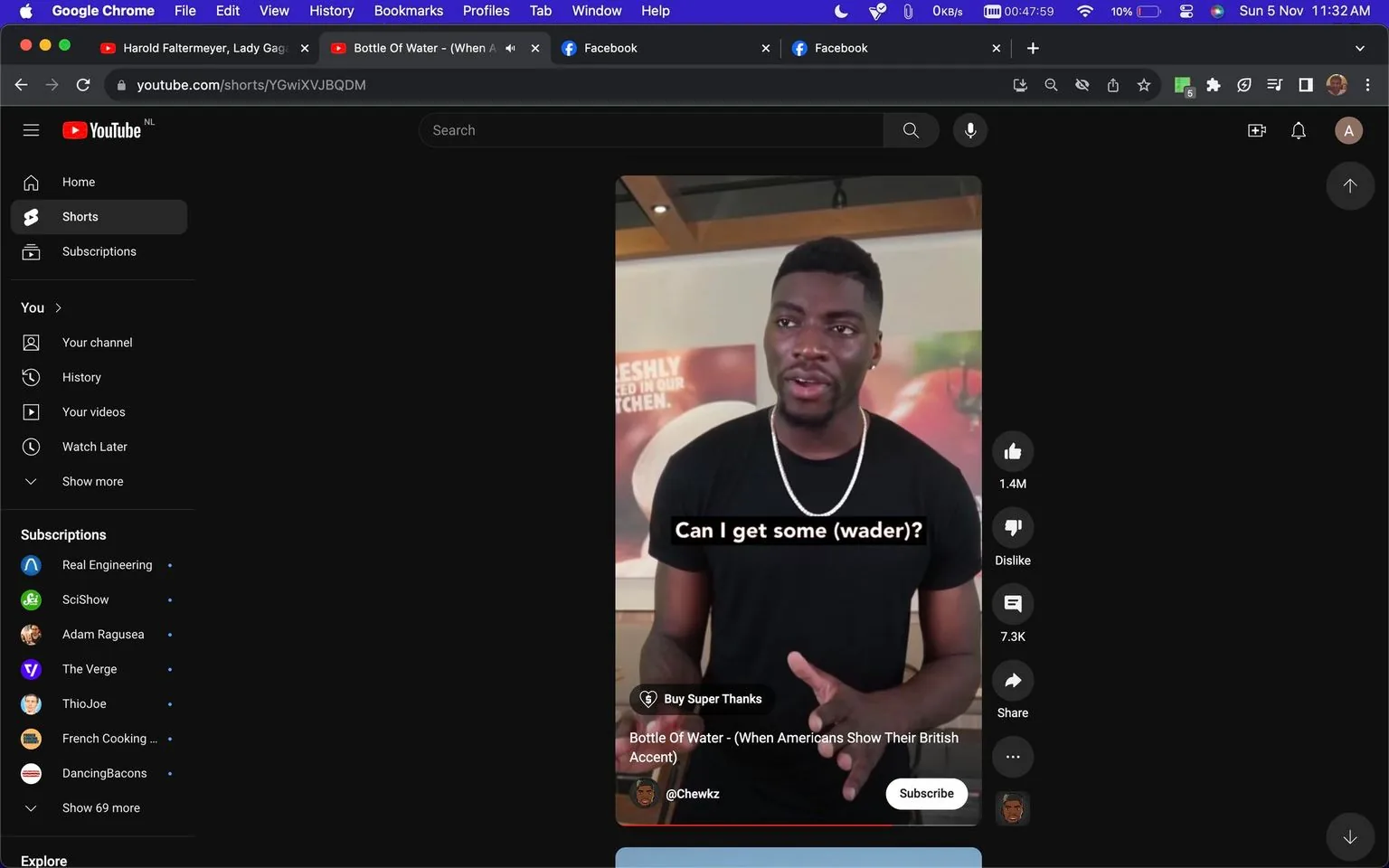 1) Rich description: The image is a screenshot from YouTube, displaying a video titled "Bottle Of Water - (When Americans Show Their British Accent)" by the channel @Chewkz. It features a man indoors, wearing a black t-shirt and a chain necklace, standing in front of a backdrop that hints at a food establishment with blurred images of vegetables. He is captured mid-sentence, engaging with an unseen audience, likely participating in a humorous skit about accents. His expression seems animated and conversational, suggesting a lighthearted tone. The lighting is bright, typical of indoor settings. On the right side of the screen are YouTube interface elements such as like and dislike buttons, with 1.4 million likes shown. The black background of YouTube's interface highlights the video's thumbnail.
2) On-screen text block:
- Title: "Bottle Of Water - (When Americans Show Their British Accent)"
- Channel / profile: "@Chewkz"
- Site / app: "YouTube"
- Captions / subtitles: "Can I get some (wader)?"