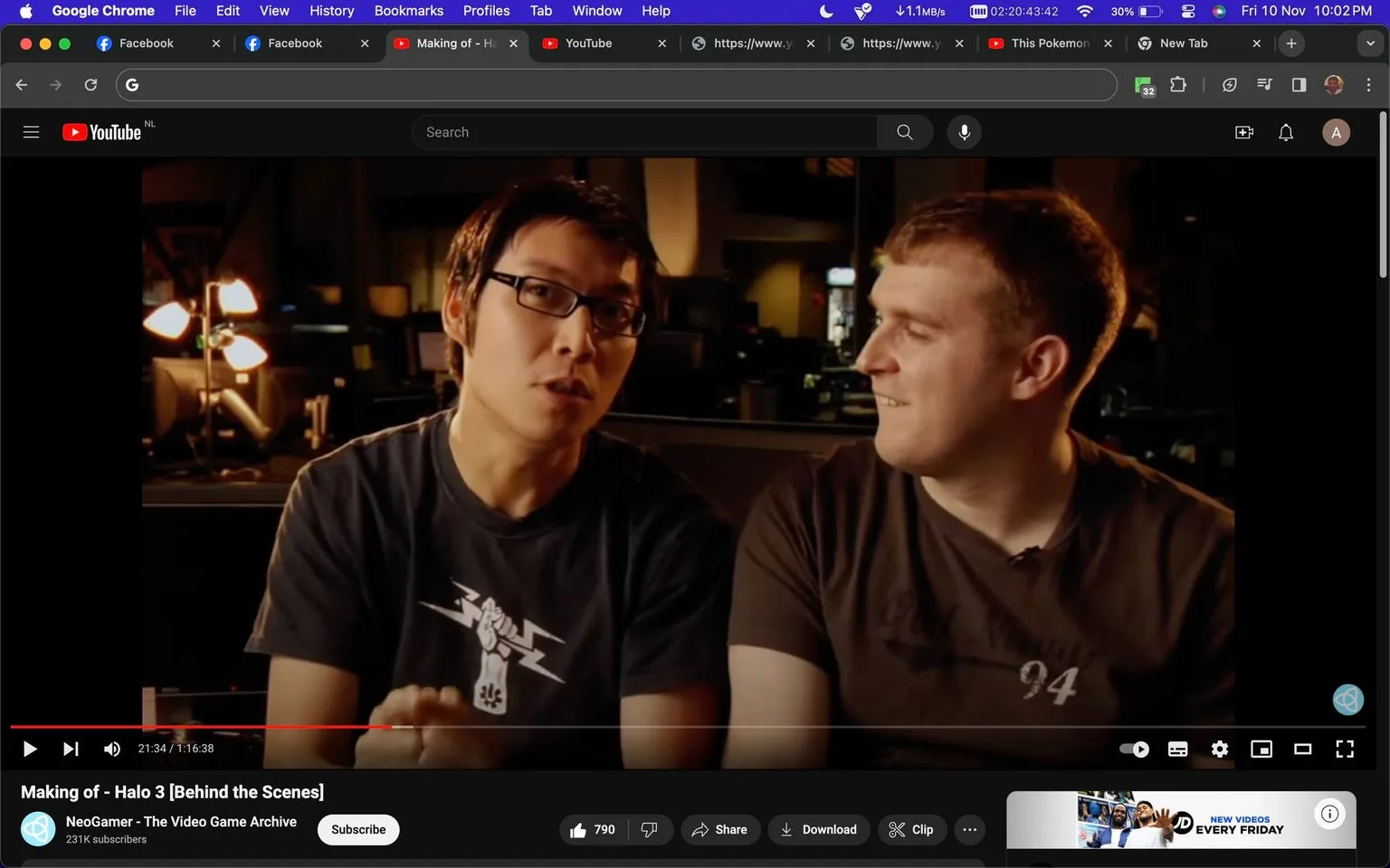 In this screenshot from a YouTube video titled "Making of - Halo 3 [Behind the Scenes]," two individuals are seated indoors, likely in a studio or office setting, as suggested by the dim lighting and presence of computer equipment in the background. The individual on the left is wearing glasses and a black t-shirt with a white graphic featuring a stylized fist and lightning bolts. The person on the right sports a brown t-shirt with a subtle design and the number "94" printed on it. The scene captures a moment of conversation or explanation, with the person on the left speaking while the other listens with a light expression, hinting at camaraderie or a shared interest. The video is part of NeoGamer - The Video Game Archive's channel, which has 231K subscribers, concentrating on content related to the video game "Halo 3." The overall mood is casual and informative, reflecting the behind-the-scenes nature of the video.
- Title: "Making of - Halo 3 [Behind the Scenes]"
- Channel / profile: "NeoGamer - The Video Game Archive"
- Site / app: "YouTube"