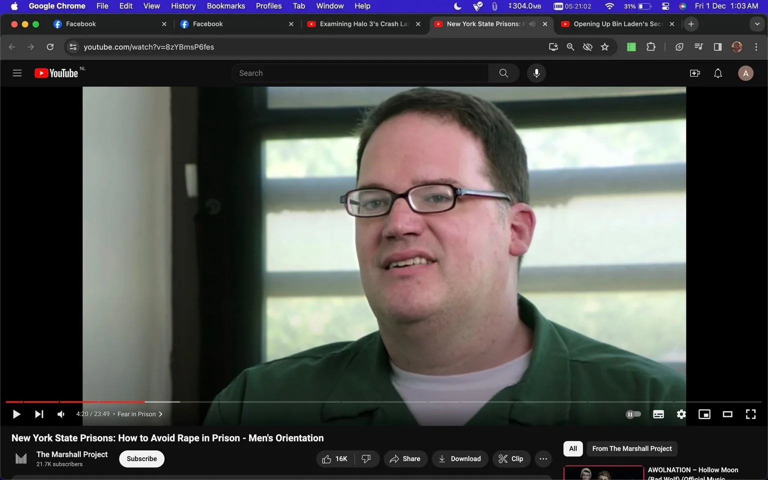 The image is a screenshot from a YouTube video titled "New York State Prisons: How to Avoid Rape in Prison - Men's Orientation," hosted on the channel "The Marshall Project." The video is mid-play at 4 minutes and 20 seconds into a total duration of 23 minutes and 49 seconds. The scene captures a close-up of a man with short hair and glasses, wearing a green shirt over a white T-shirt. He appears to be speaking in an interview setting, seated indoors with a window in the background, allowing natural light to illuminate the space. His expression seems thoughtful, suggesting he is discussing the serious topic indicated by the video's title. The user interface shows standard YouTube elements, including options to like, share, and download the video, with a visible like count of 16K. The video's theme focuses on prison safety and orientation, as indicated by the title and topic tags. The environment is simple and functional, reflecting the informative and serious nature of the video content.