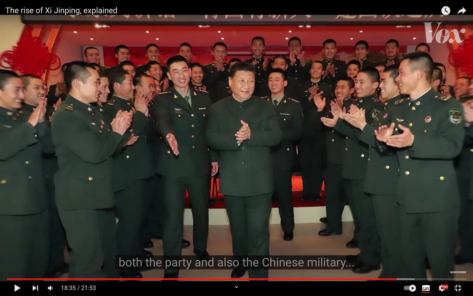 Xi Jinping is at the center of a celebratory scene involving a group of uniformed military personnel. Xi, wearing a dark green military-style suit, is surrounded by individuals clapping and smiling, indicating a positive and supportive atmosphere. The background is warmly lit with a red hue, enhancing the celebratory mood. The military personnel are in matching dark green uniforms adorned with various insignias, suggesting a formal military event. The individuals are positioned in rows, with some standing on a raised platform to ensure everyone is visible, emphasizing the collective nature of the gathering. The composition centers on Xi Jinping, highlighting his prominence in the scene. The setting appears to be indoors, possibly a hall or a room within a government or military building. The overall mood is one of camaraderie and respect, with the focus on Xi Jinping's role within both the party and the Chinese military.
- Title: "The rise of Xi Jinping, explained"
- Channel / profile: "Vox"
- Site / app: "YouTube"
- Captions / subtitles: "both the party and also the Chinese military..."
