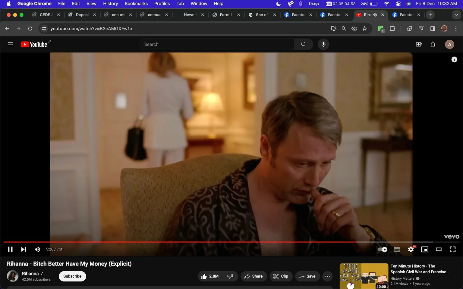 The image is a screenshot from a YouTube video titled "Rihanna - Bitch Better Have My Money (Explicit)" on Rihanna's official channel. The scene features Mads, who is sitting in an elegant room, wearing a patterned robe. The setting appears luxurious, with warm lighting and a sophisticated decor. Mads is seated in a chair and seems deep in thought or concerned, evident from his posture and expression. In the background, a person in a white outfit is walking away, carrying a black bag, adding a sense of narrative tension. The room is tastefully decorated, with a lamp on a table creating a cozy ambiance. This frame captures a moment of introspection or tension, fitting the intense and dramatic themes typically found in music videos of this nature.
- Title: "Rihanna - Bitch Better Have My Money (Explicit)"
- Channel / profile: "Rihanna"
- Site / app: "YouTube"