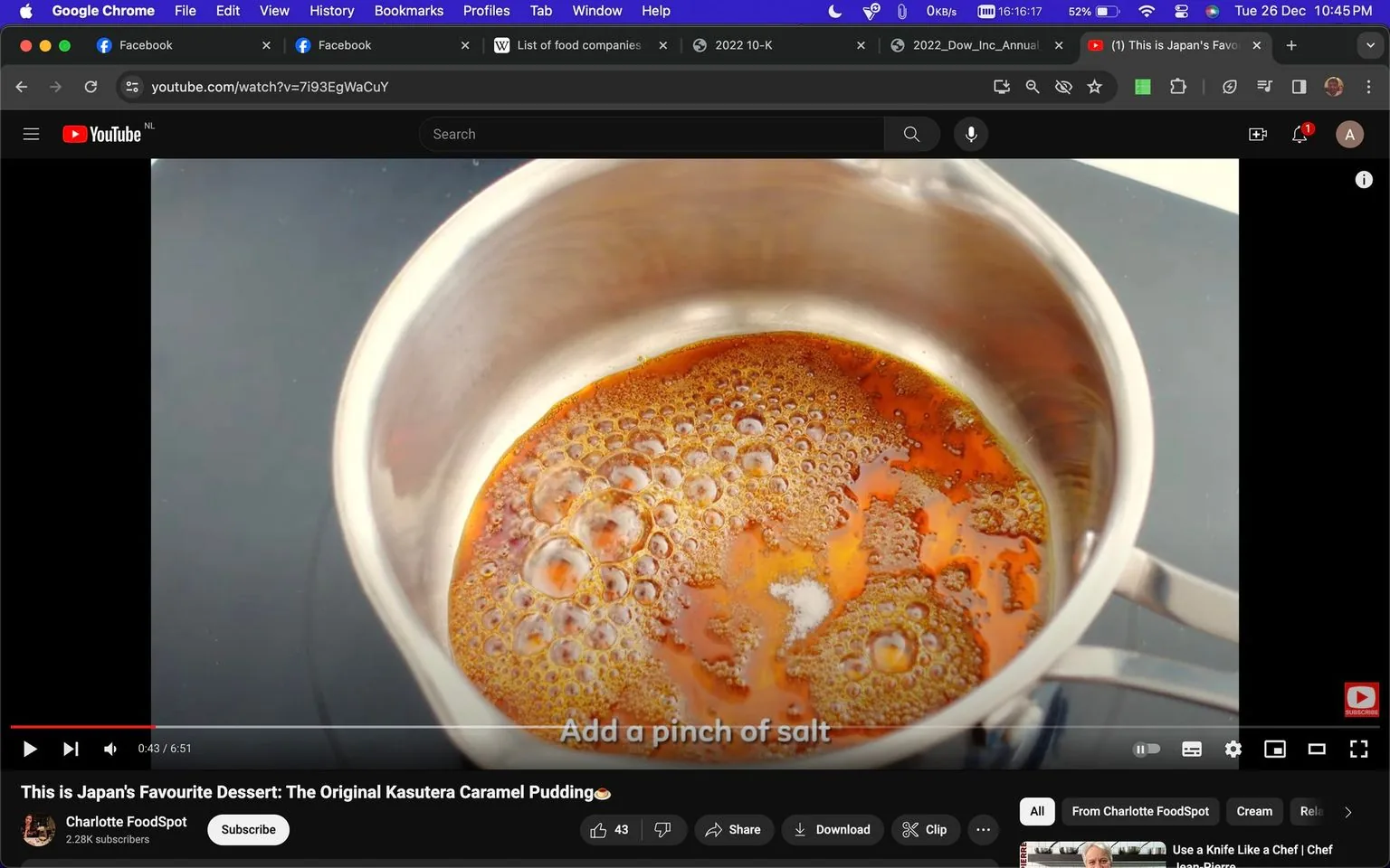 The image is a screenshot from a YouTube video titled "This is Japan's Favourite Dessert: The Original Kasutera Caramel Pudding🍮" by the channel Charlotte FoodSpot. In the frame, a saucepan is prominently featured containing caramelizing sugar, with bubbles forming on the surface, suggesting the process of making caramel. The scene is likely set in a kitchen, as indicated by the cooking activity. The on-screen text reads "Add a pinch of salt," indicating a step in the recipe. The video's interface shows standard YouTube features like the play button, volume control, and video timeline. The background is simple, keeping the focus on the saucepan and its contents, which are a rich, golden-brown color. The overall lighting is bright, typical for a cooking tutorial, to clearly display the cooking process.